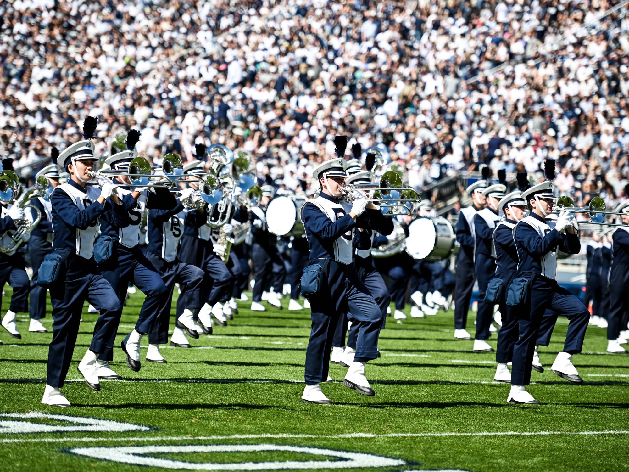 Marching band performing on a football field.