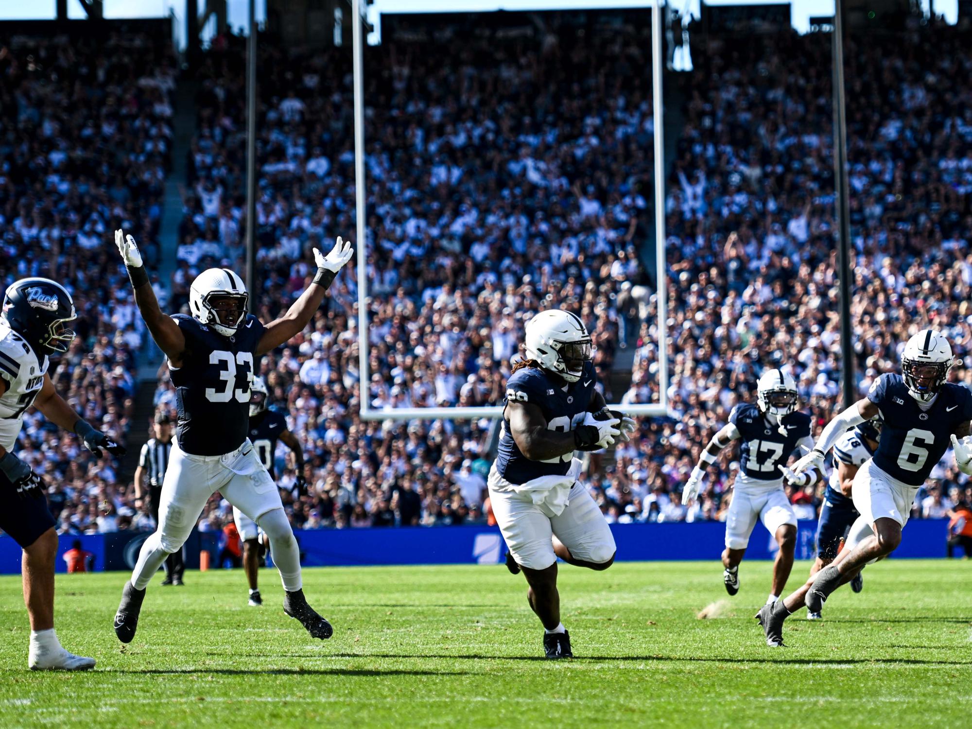 A football player running with a football on the field.