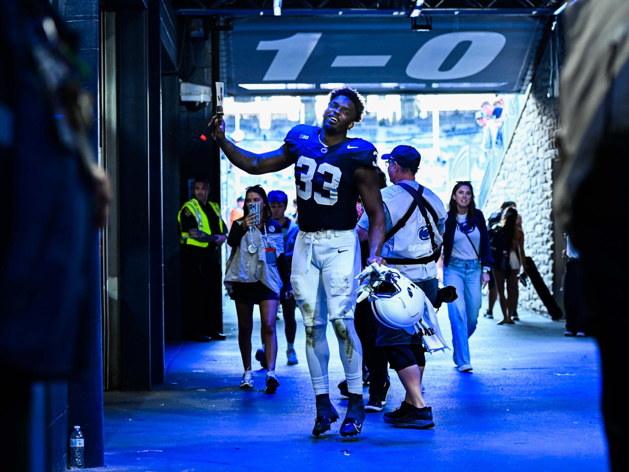 A football player celebrating and runnning back to the locker room.