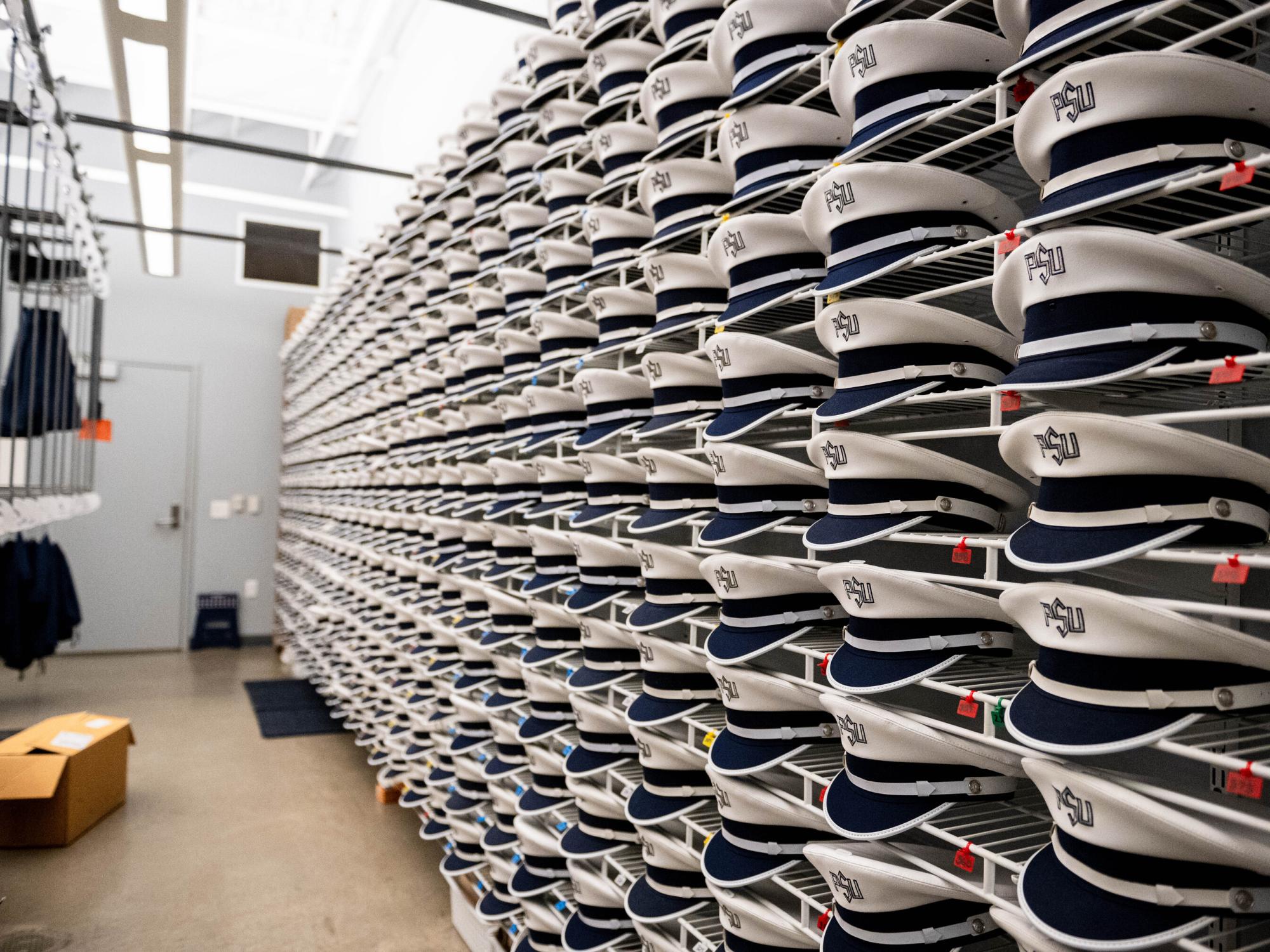 A wall of shelves holding hats for Penn State Blue Band members