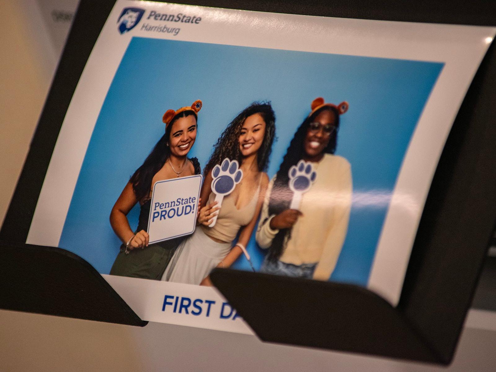 A picture of an instant-print photograph showing three students at Penn State Harrisburg