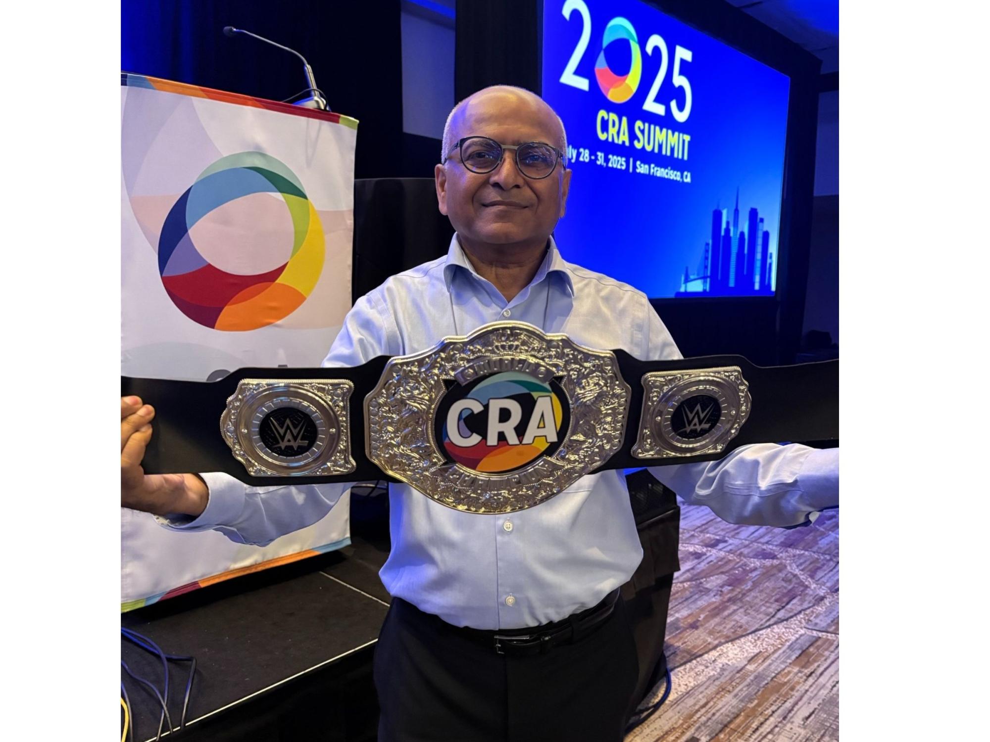 person at 2025 conference displays championship wrestling belt
