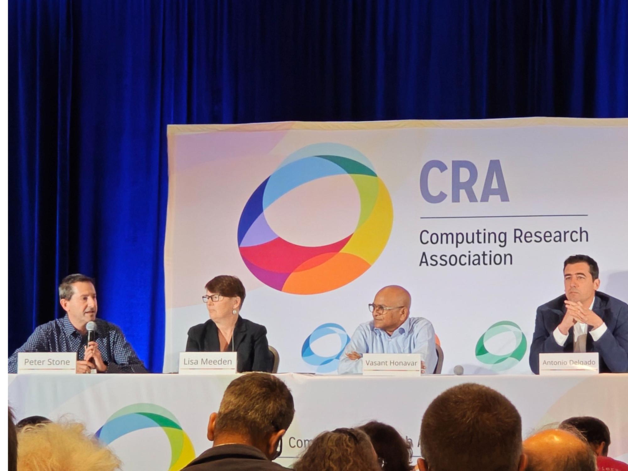 four seated panelists at industry conference
