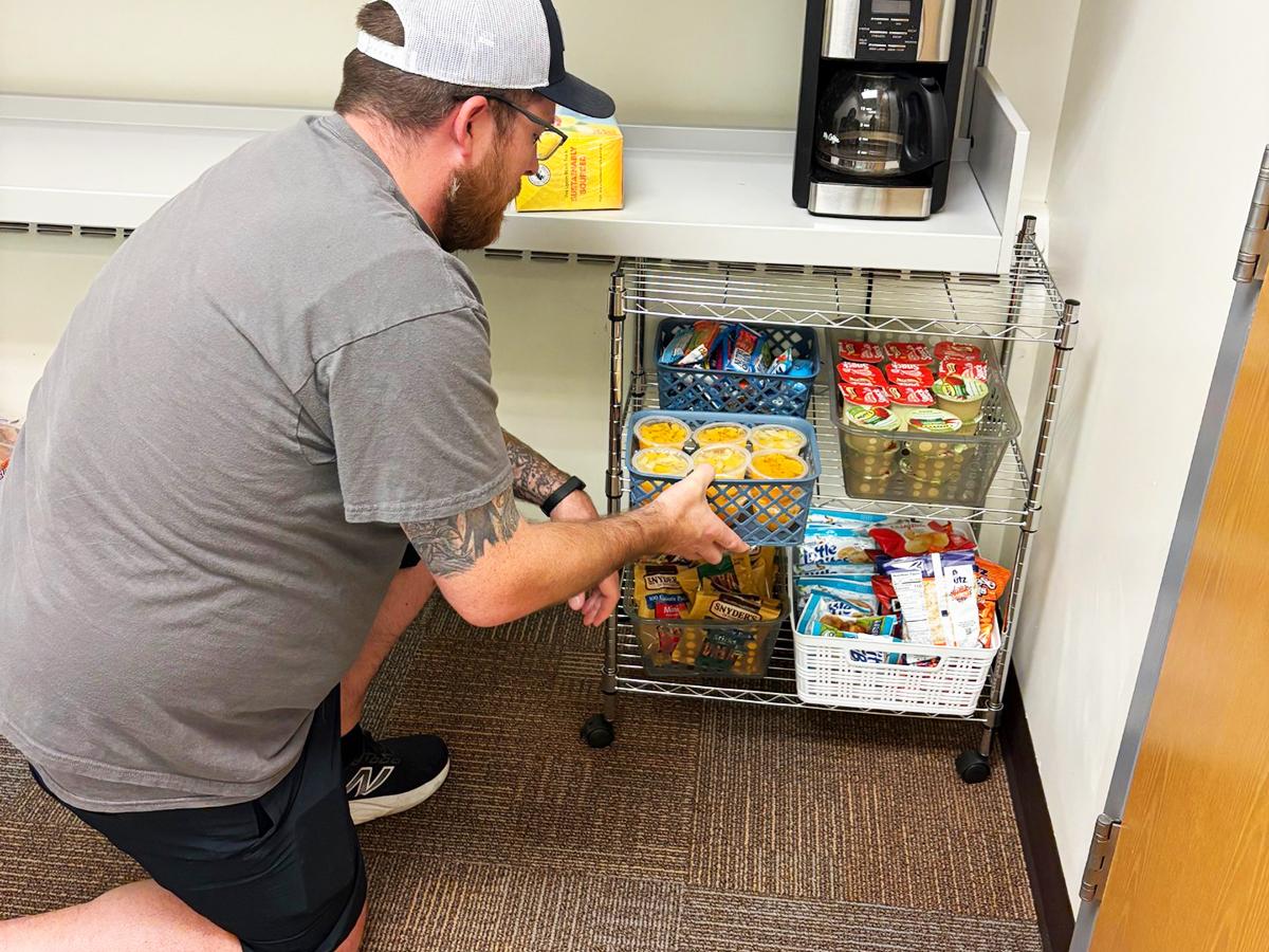 Michael Balmforth stocking a refrigerator in the Veterans Lounge