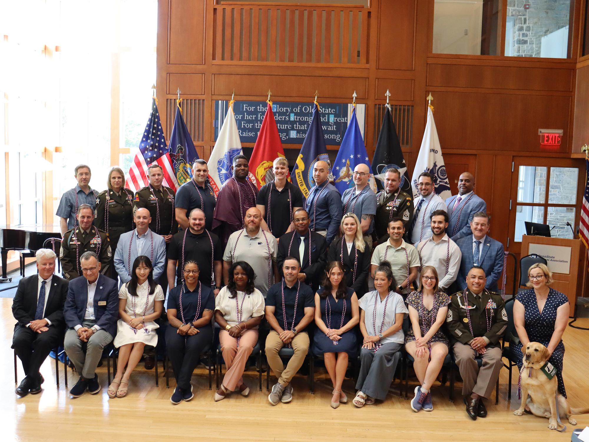 A large group of people pose for a photo in a room.