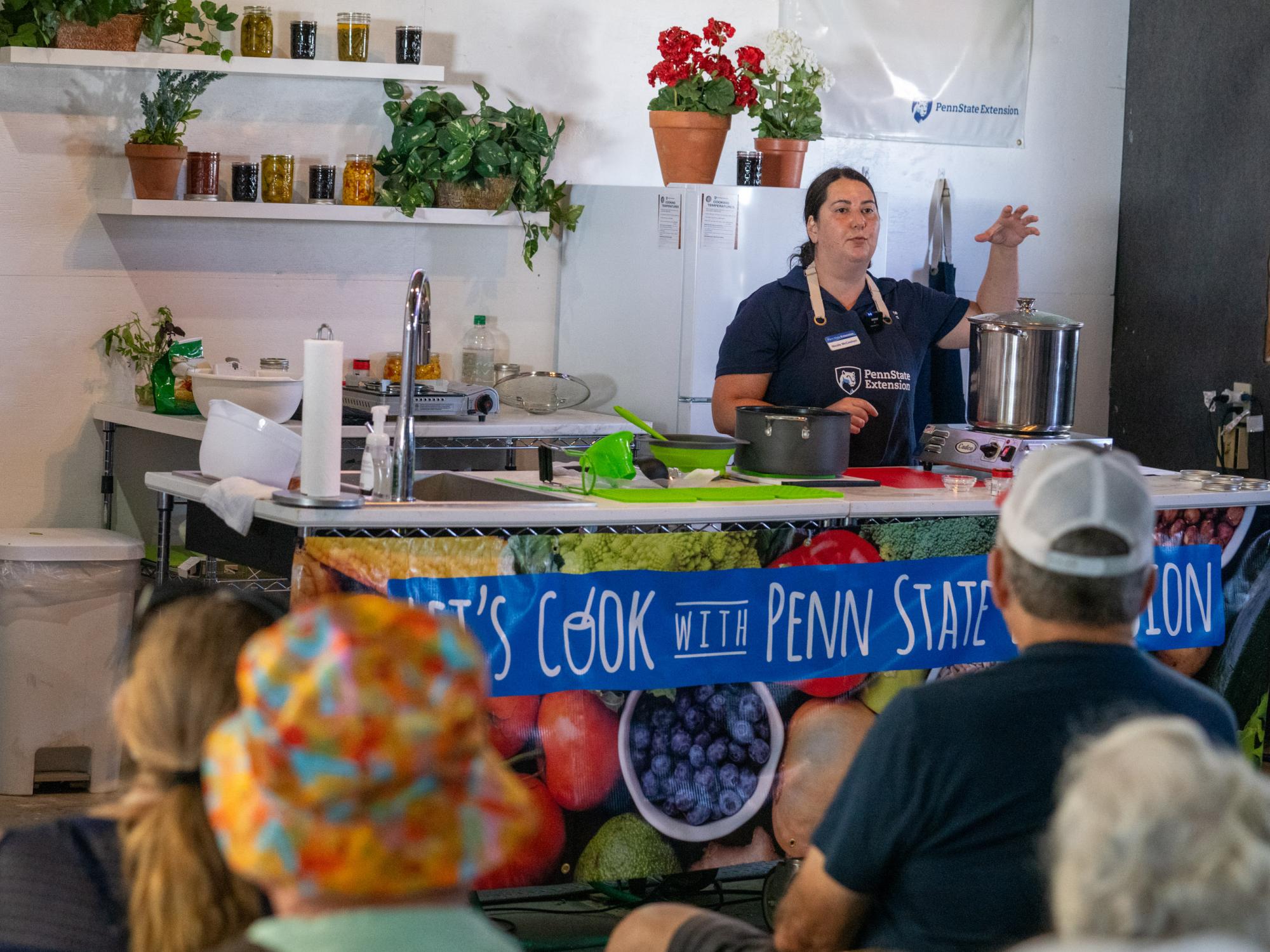A woman makes a demonstration in front of a crowd