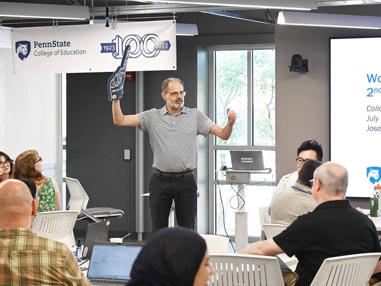 World Campus D.Ed. program director Joe Polizzi uses a blue foam finger to get the attention of the group.