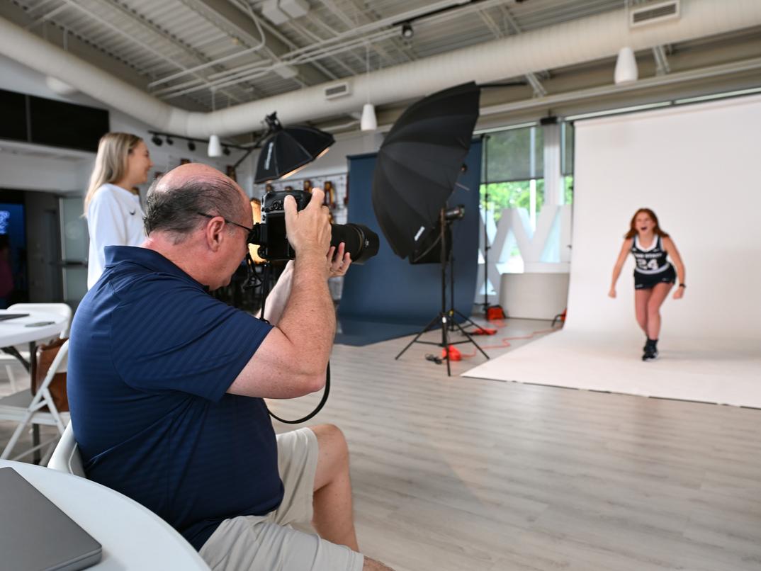 A photographer takes a picture of a student athlete