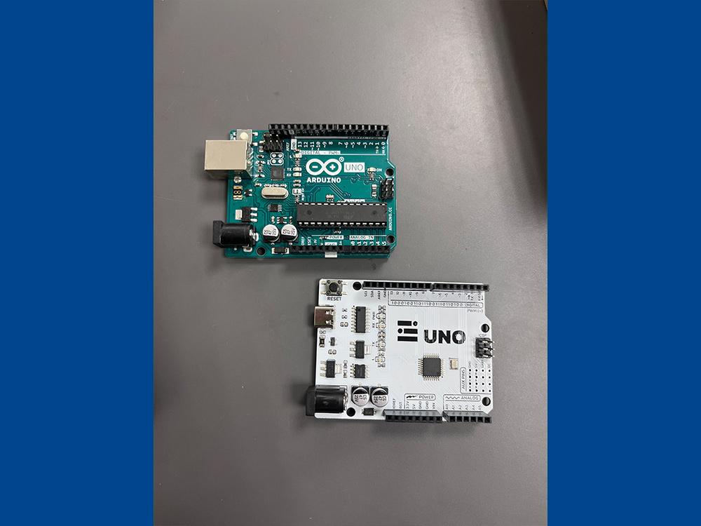 Picture of two Arduino microcontrollers sitting on a table.