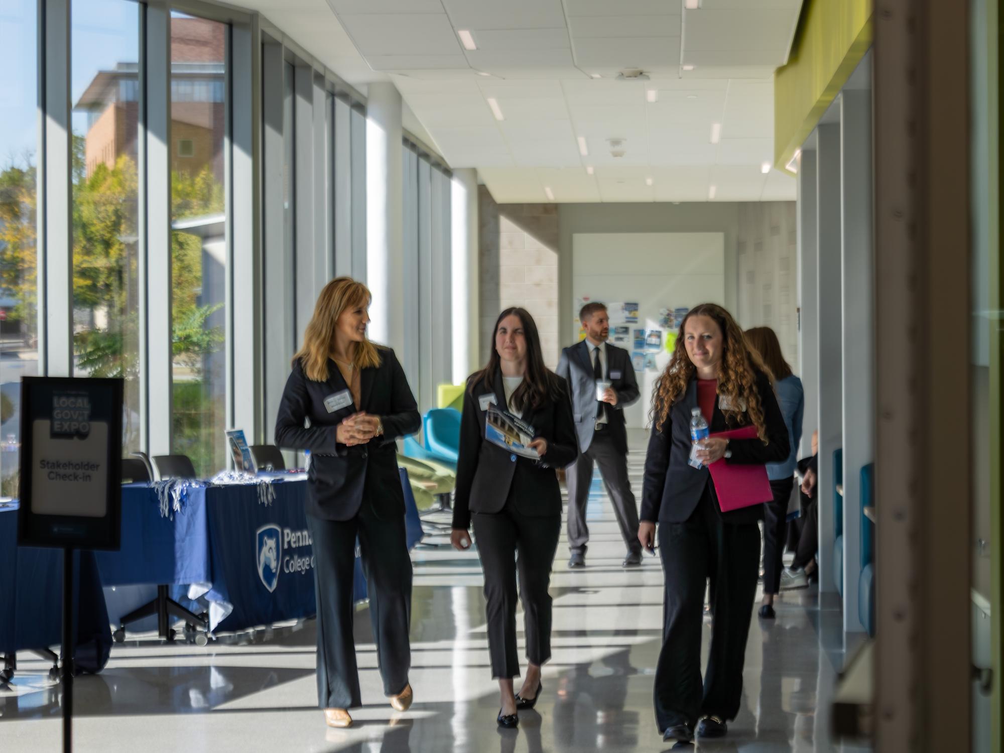 Three students enter the Local Government Expo held in the Welch Building