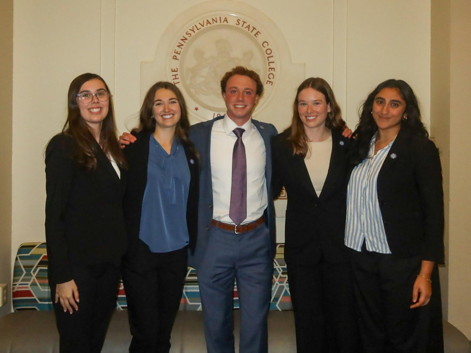 Zachary Graaf wears a suit and tie and gathers with fellow executive board members of the Liberal Arts Ambassadors.