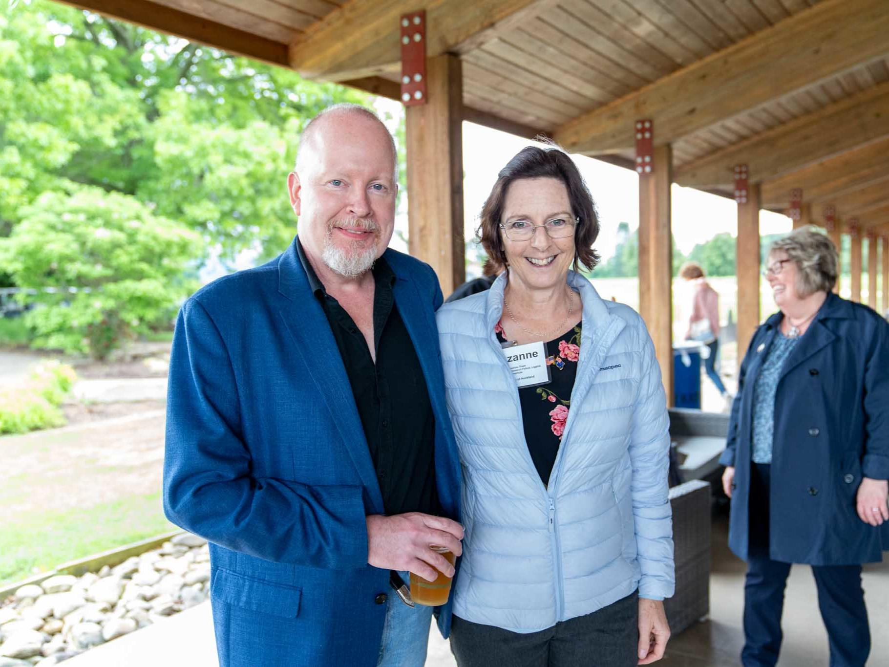 A man and a woman standing side by side under a gazebo roof