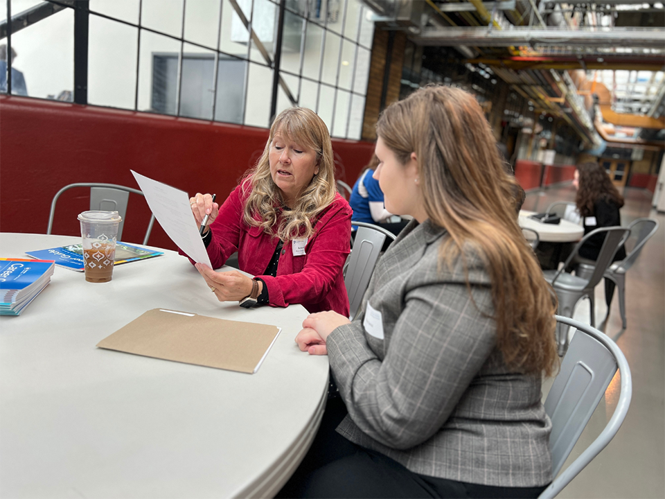 Woman talking with student at a table