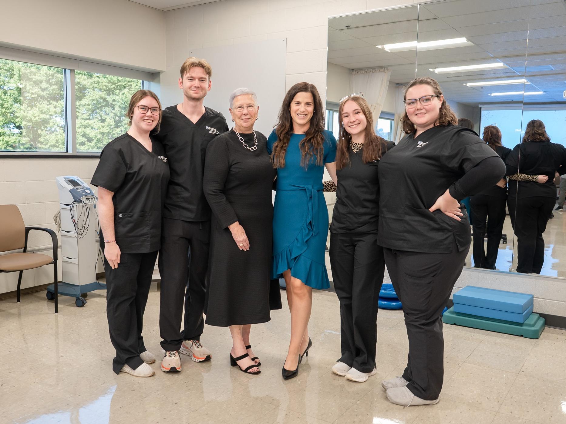 Six people stand in a row inside Penn College's Physical Therapy Clinic