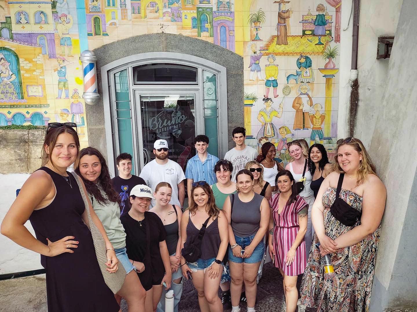 Students in the Language and Culture faculty-led program to Salerno, Italy stand in front of ceramic tiles in Vietri.