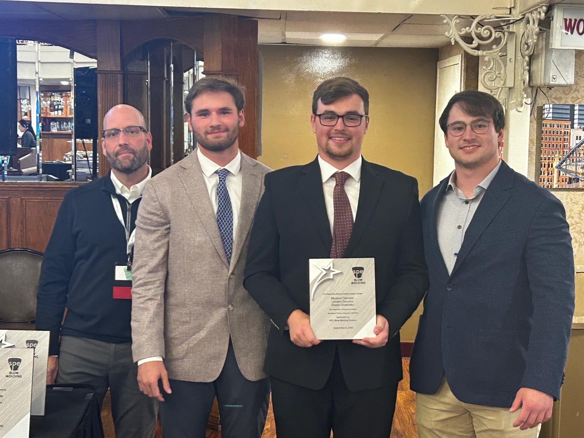 A student team poses with a certificate after the design competition at the SPE conference in Pittsburgh.