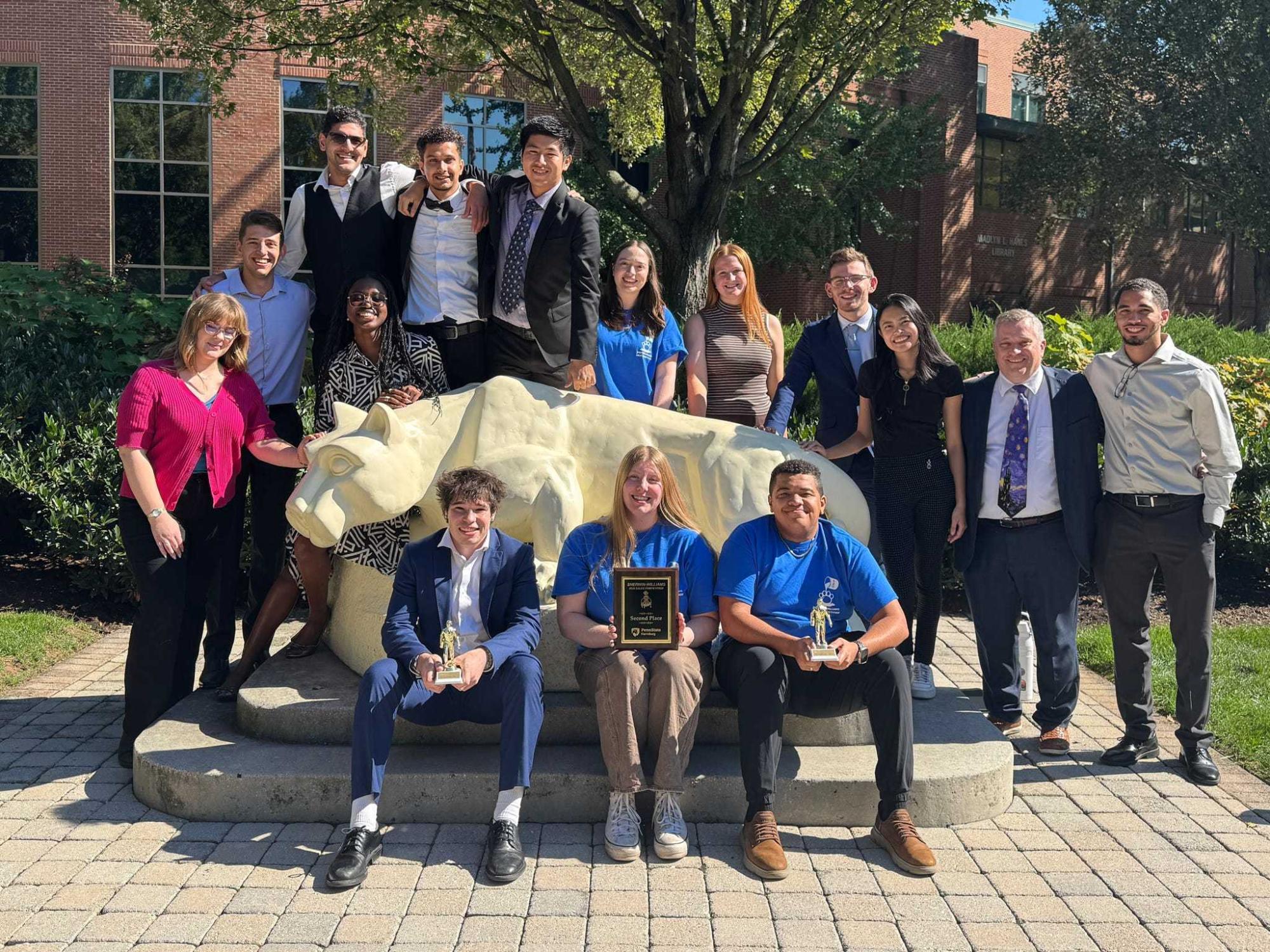 Penn STate Harrisburg students and faculty pose around the Lion statue