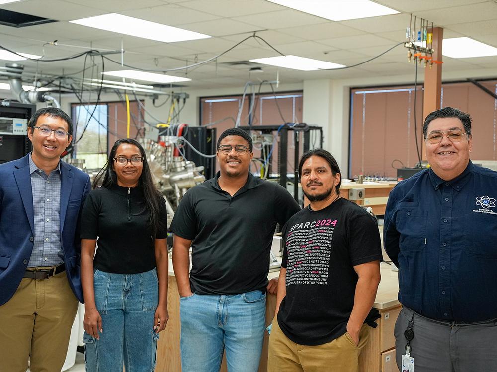  Lab team posing and smiling at the camera in their lab.