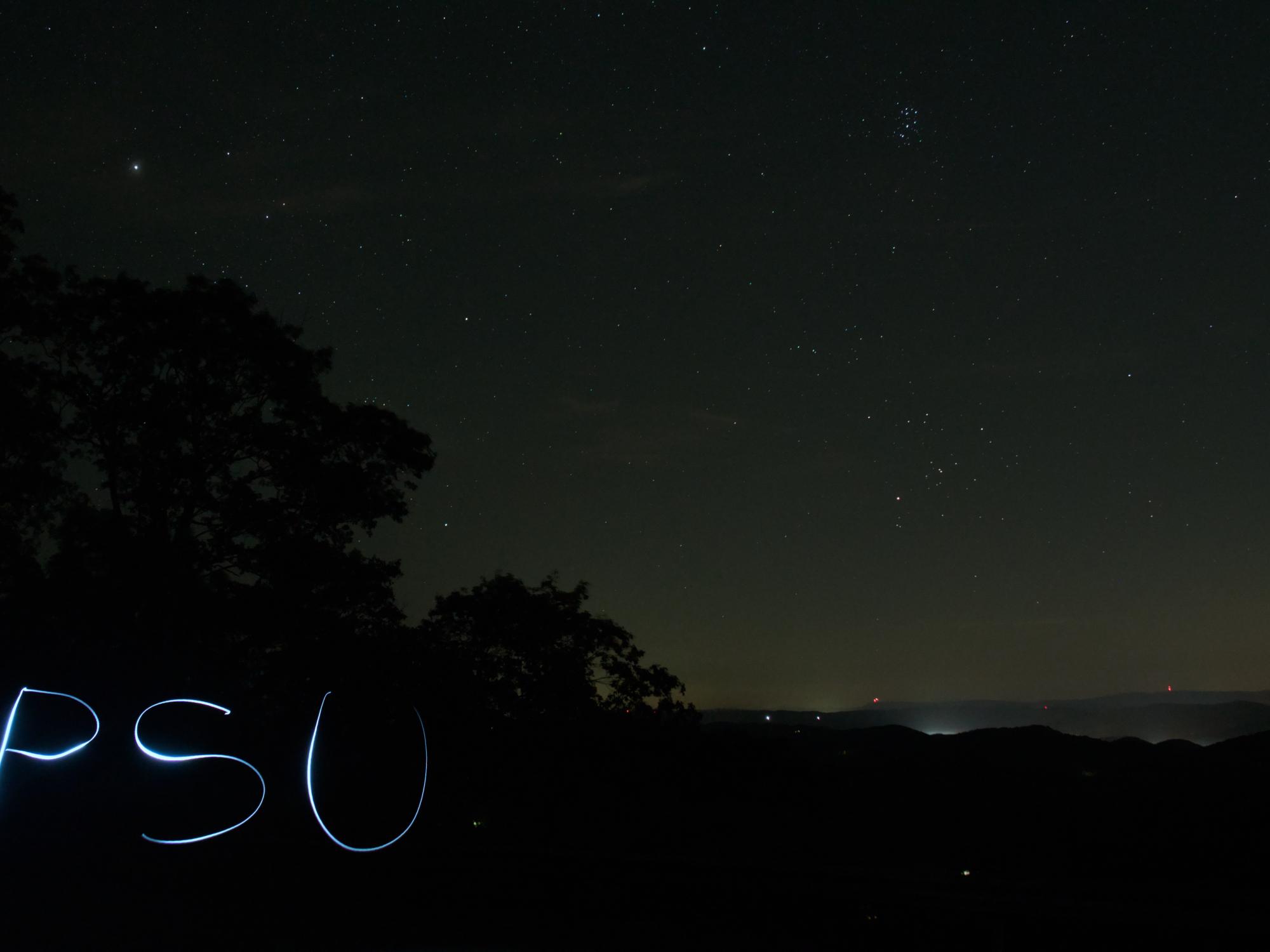 A dark outdoor photo with a dim lit "PSU" in the lower left corner