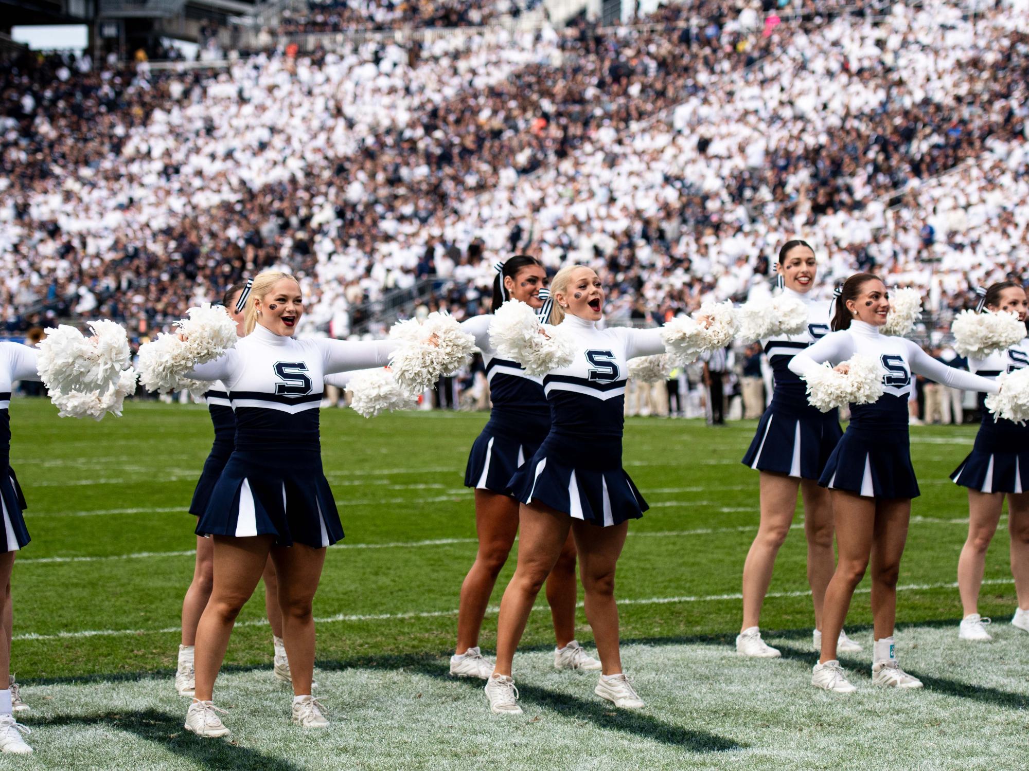 Cheerleaders cheering on a football field 