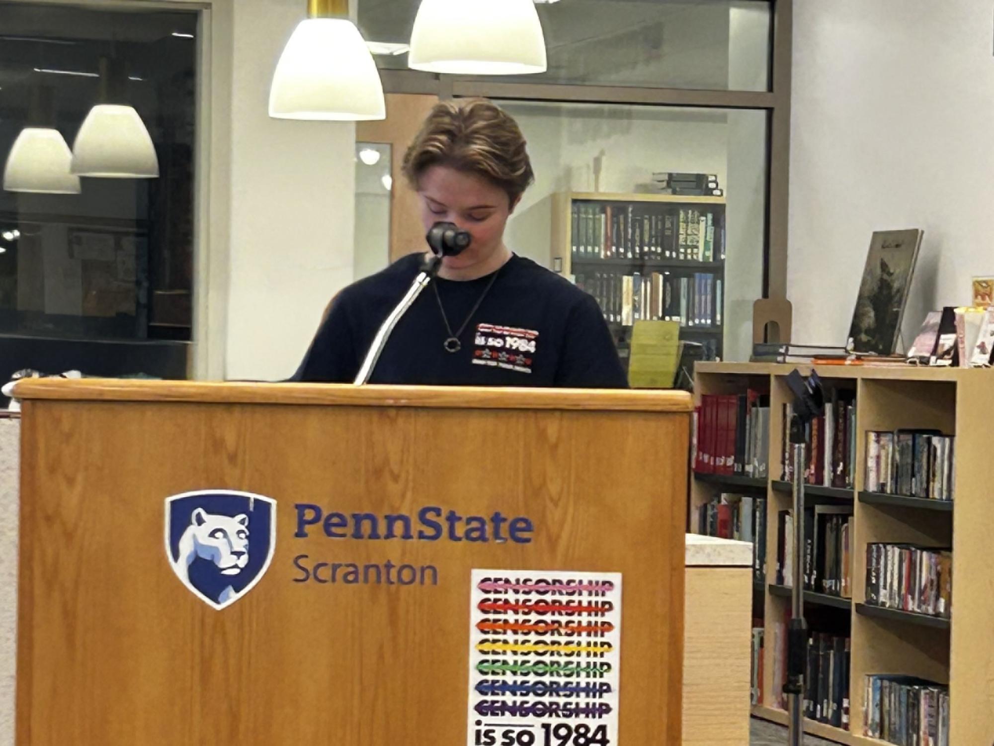 student reads at podium