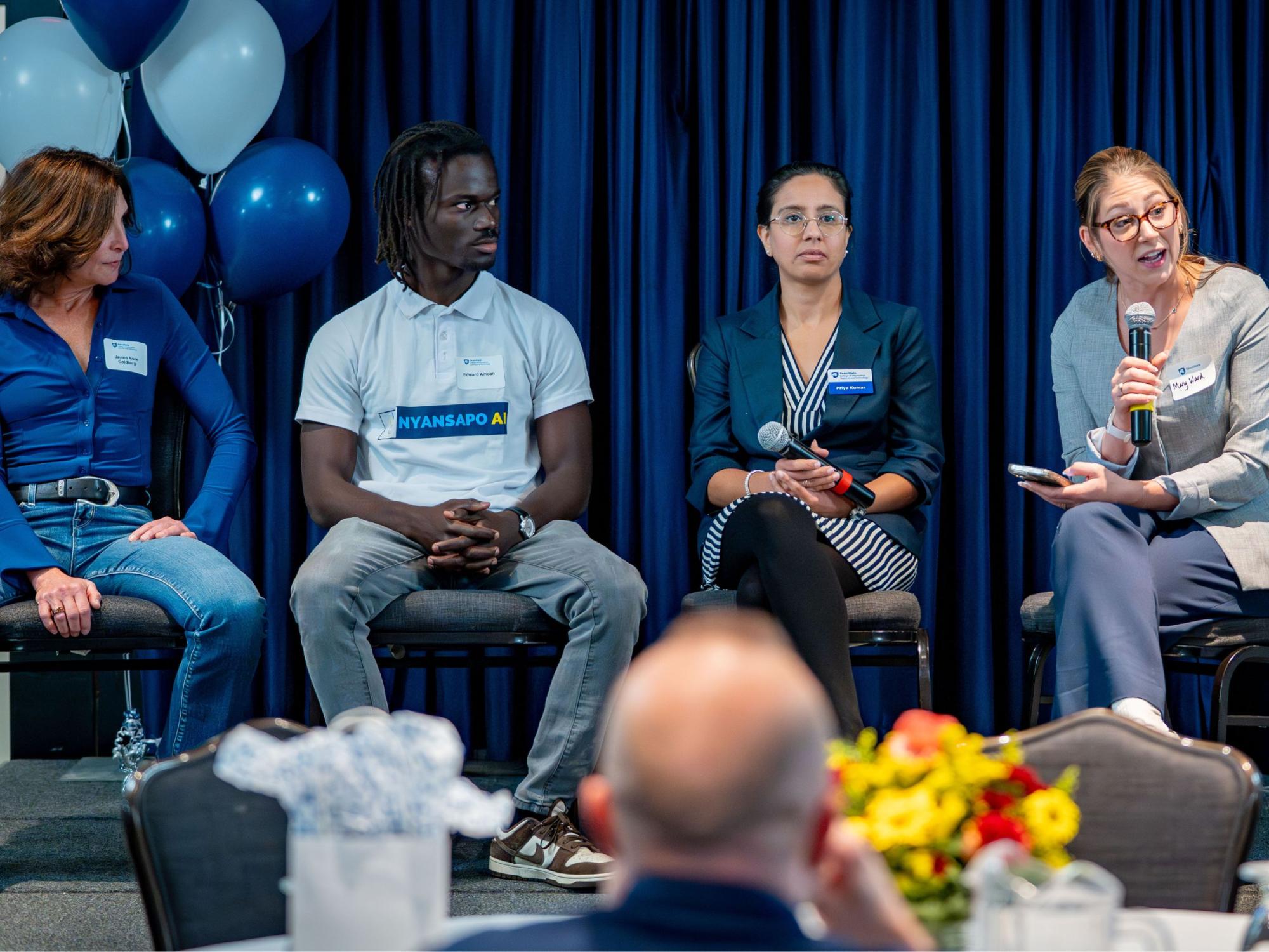 panel of four people at on stage at conference