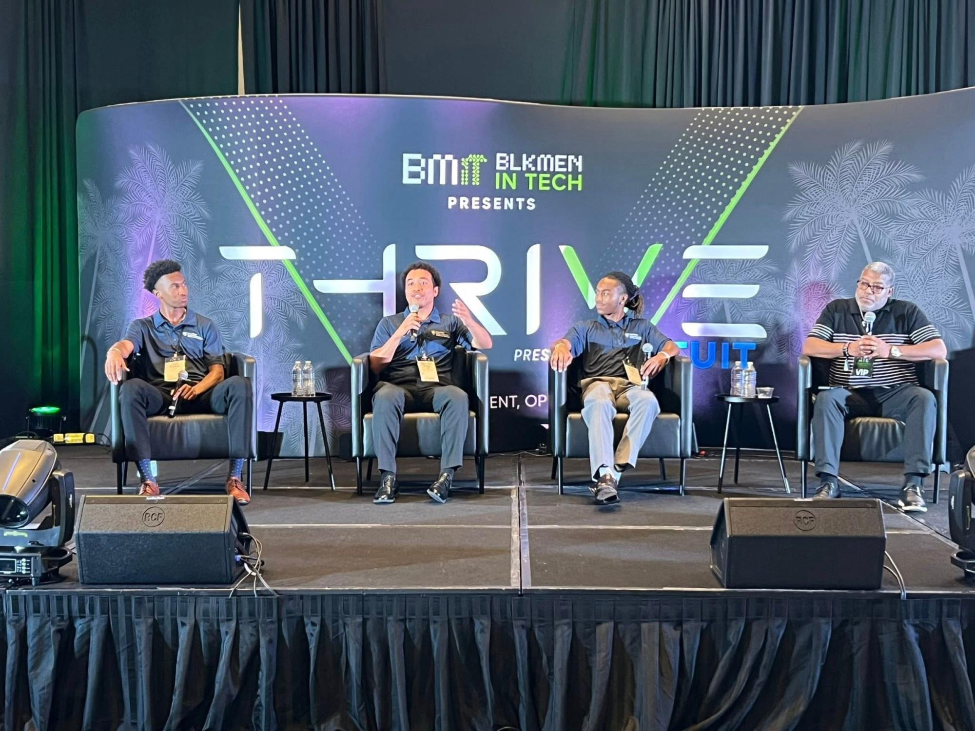 four panelists seated on stage at conference
