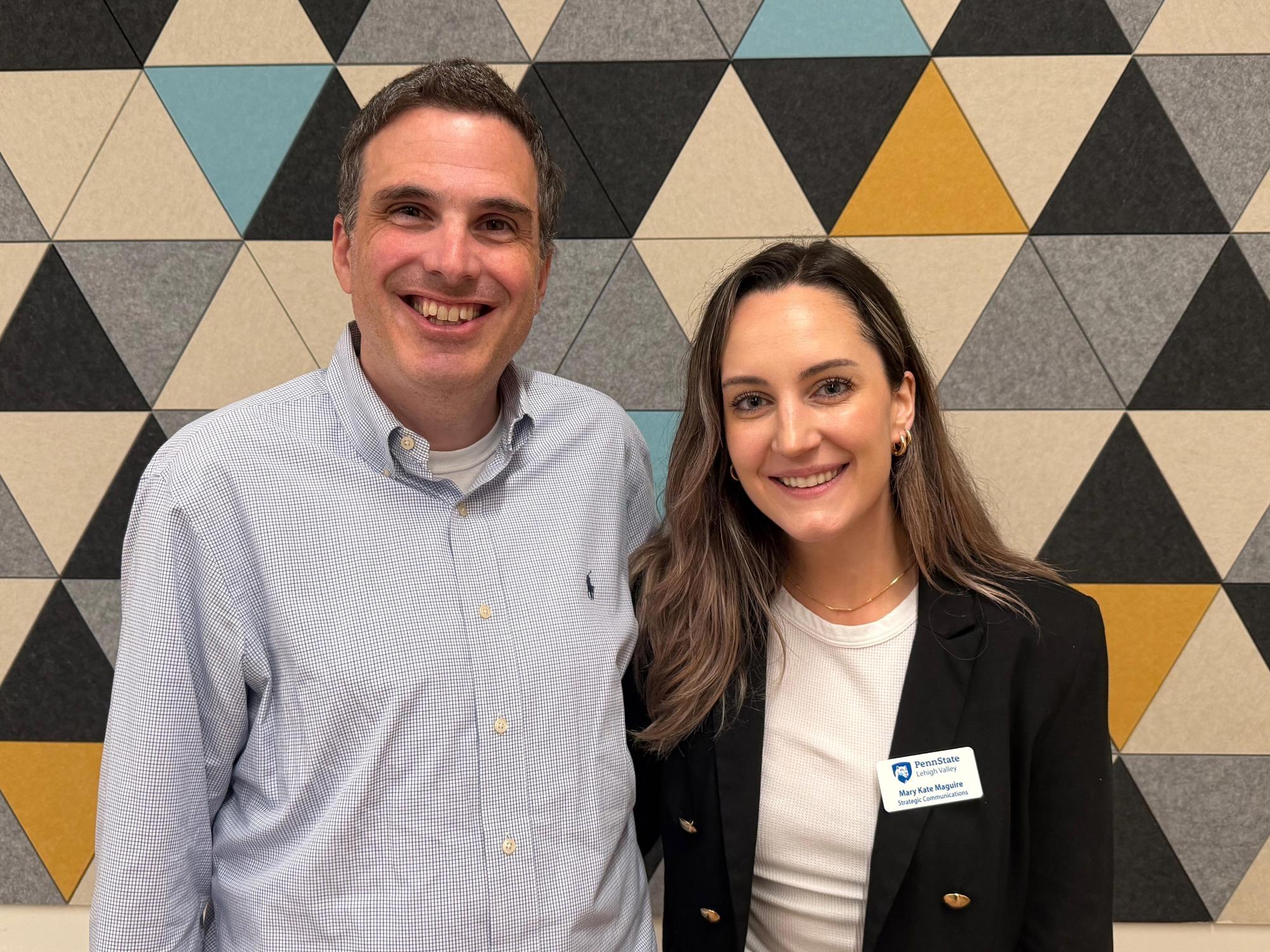 Ryan Abramson and Mary Kate Maguire standing together in front of a wall at Penn State