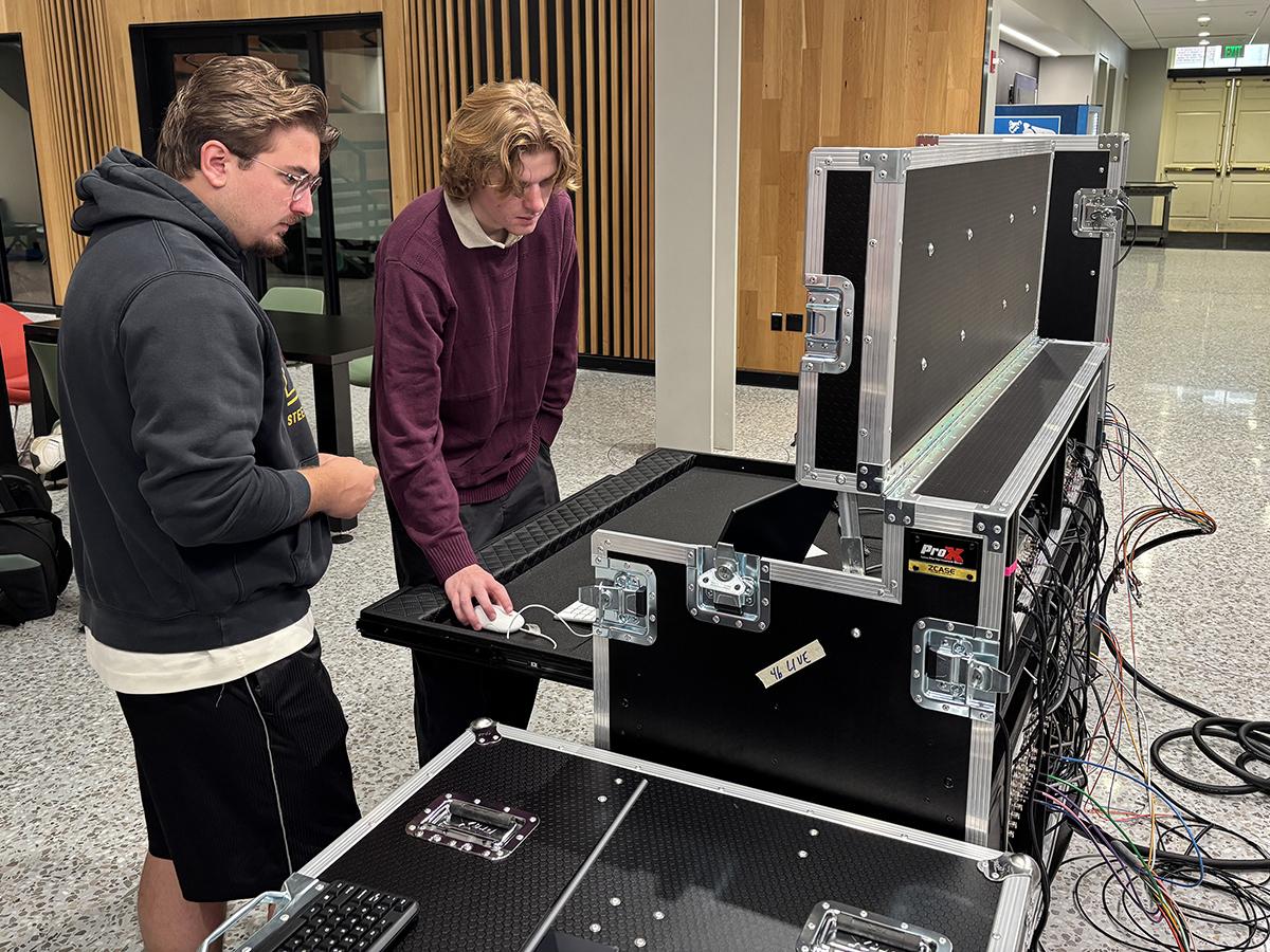 Two students working with a computer on a production case