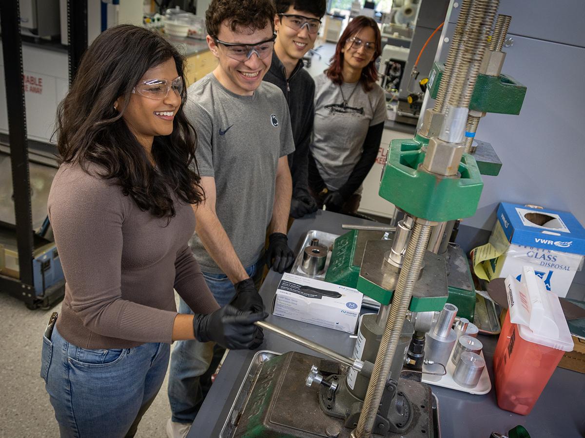 Students wearing lab glasses work on lab equipment 