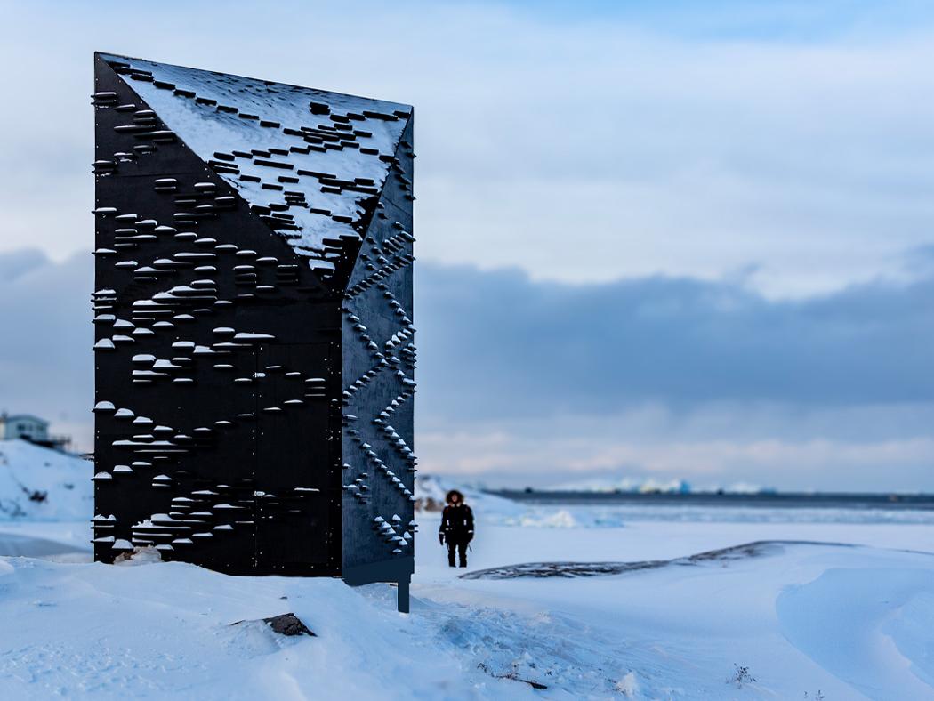 A building on a frozen landscape with the silhouette of a person next to it.