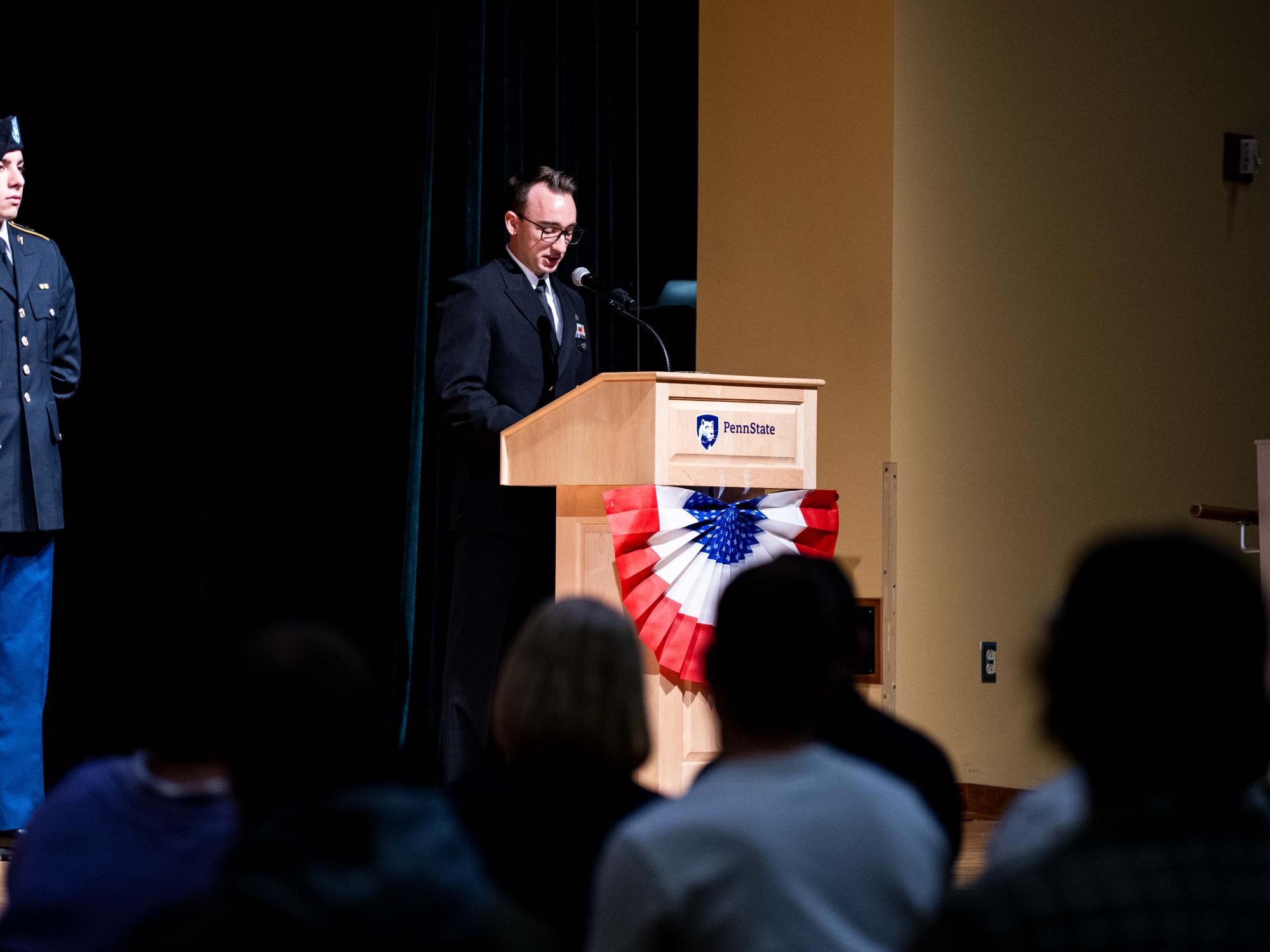 A person speaking at a podium on stage