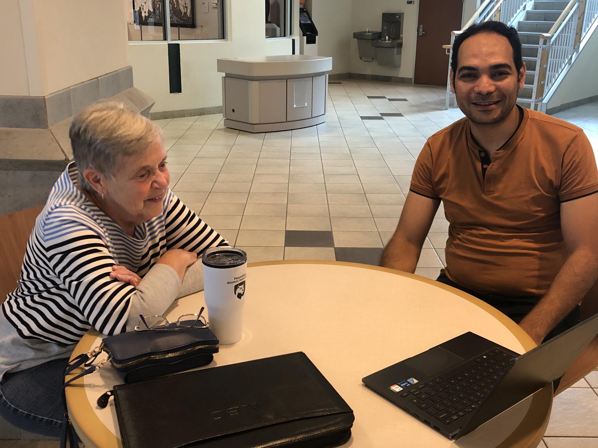 A woman and a man sitting at a table conversing