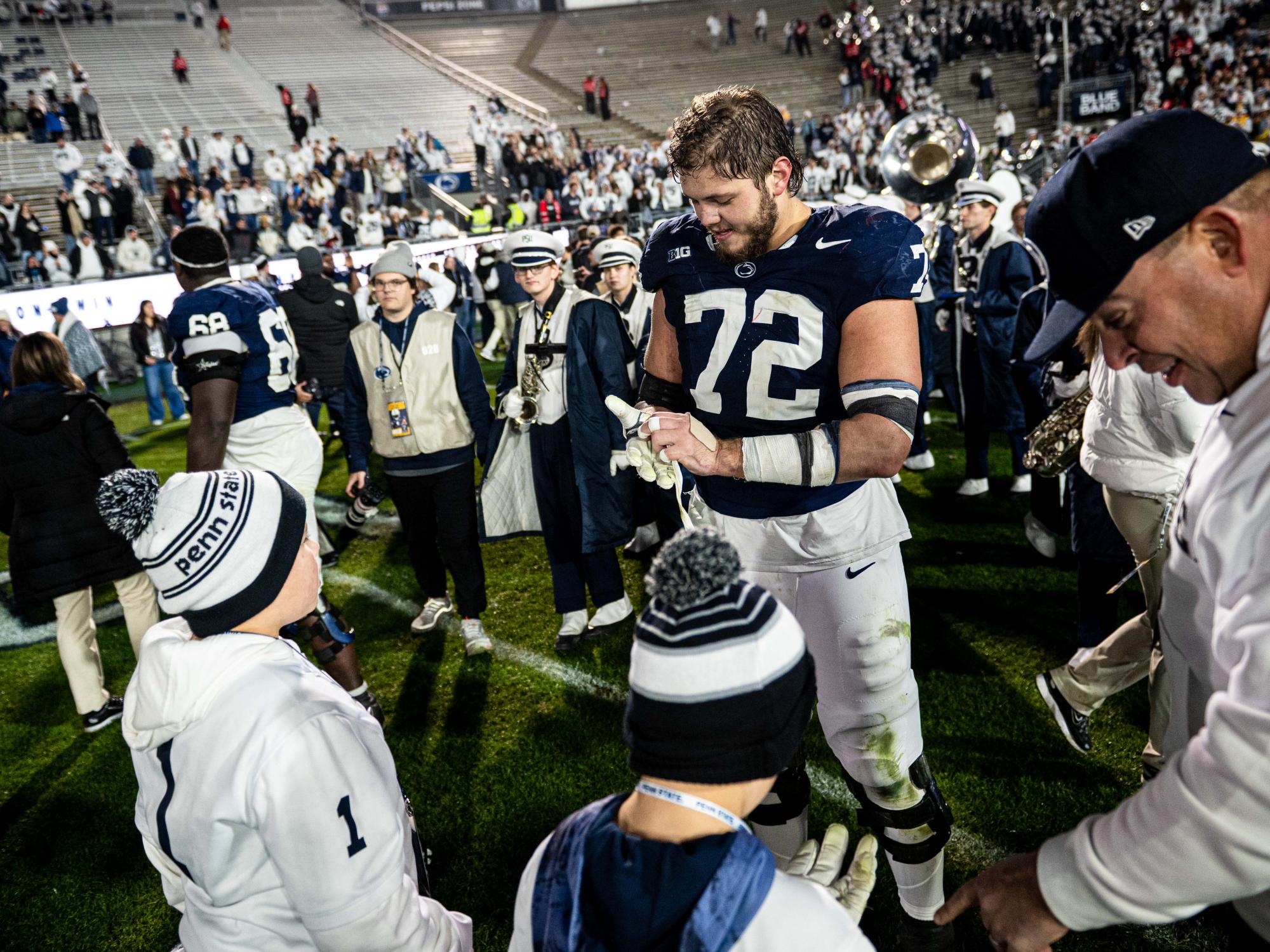 A football player takes off his gloves to give to kids