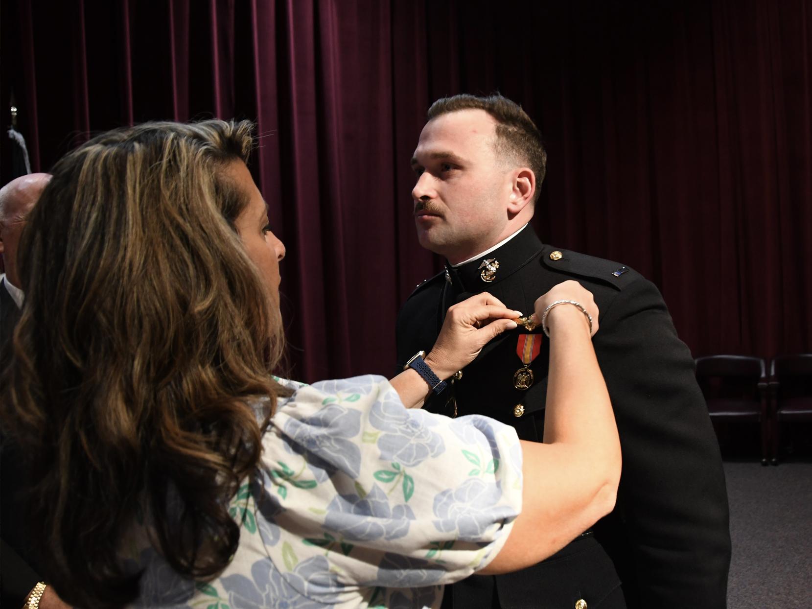 Amy Atkins pins gold aviator wings to her son's military uniform