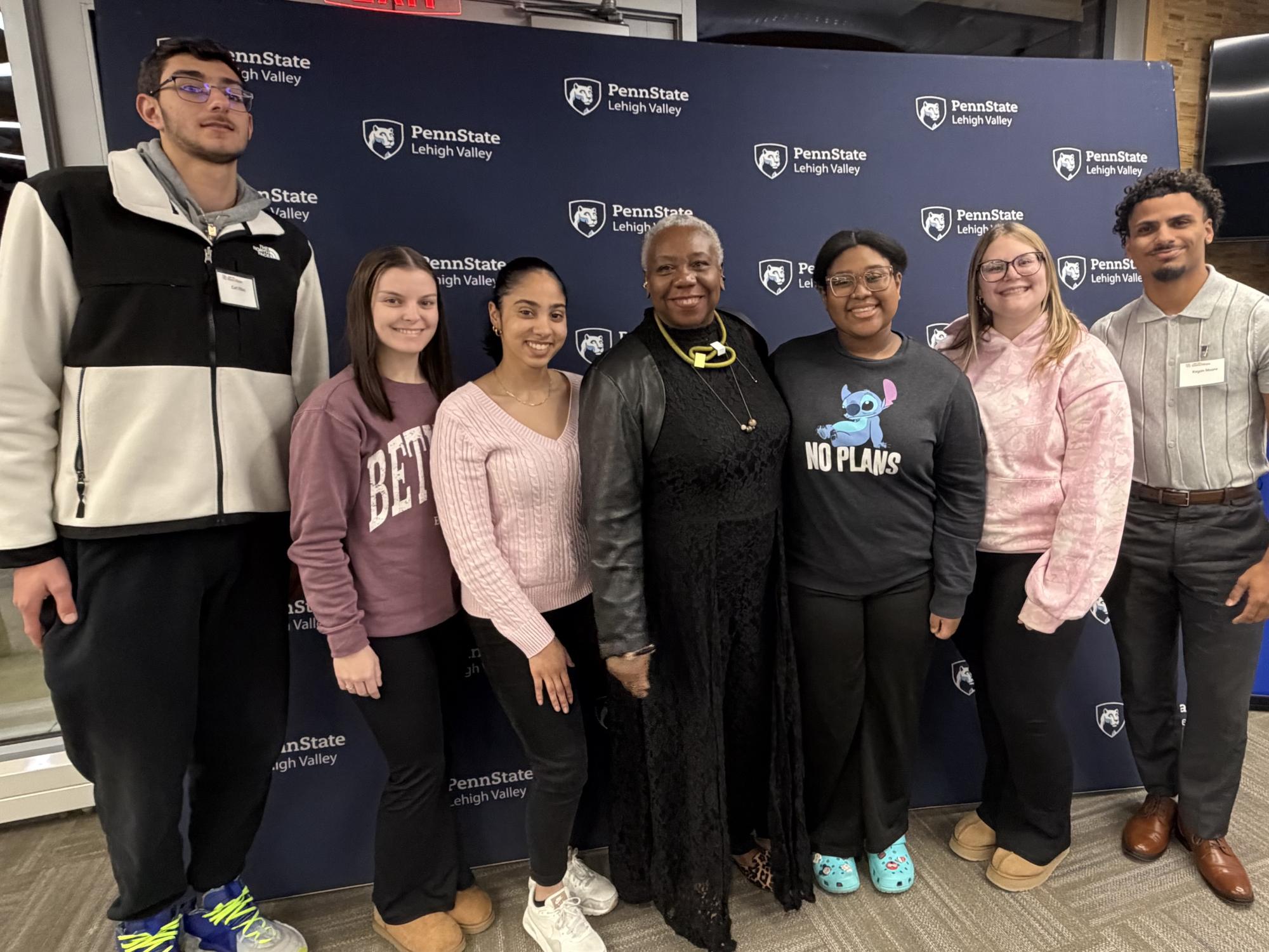 students in front of a step and repeat banner