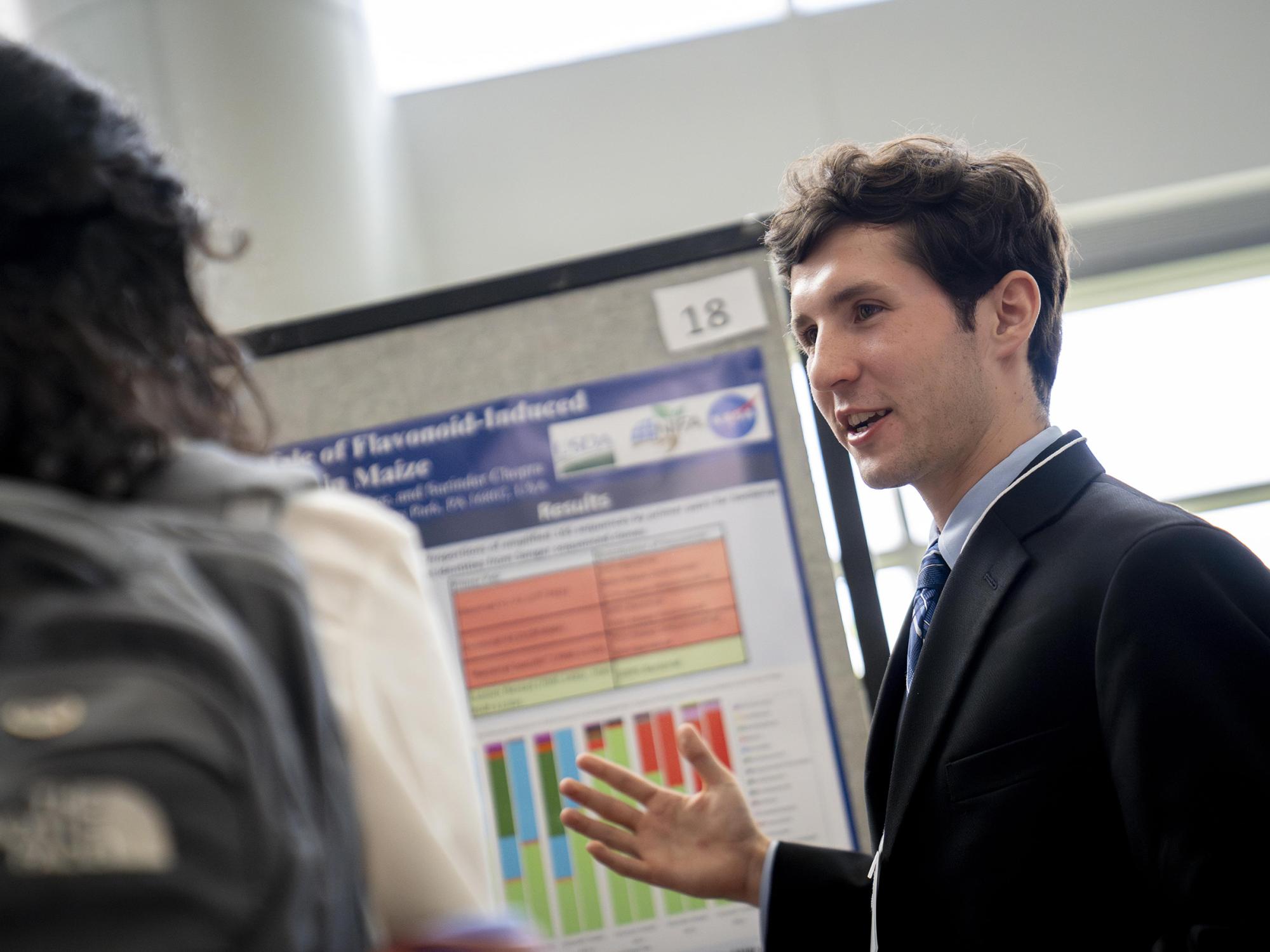 A student researcher presents at a poster session