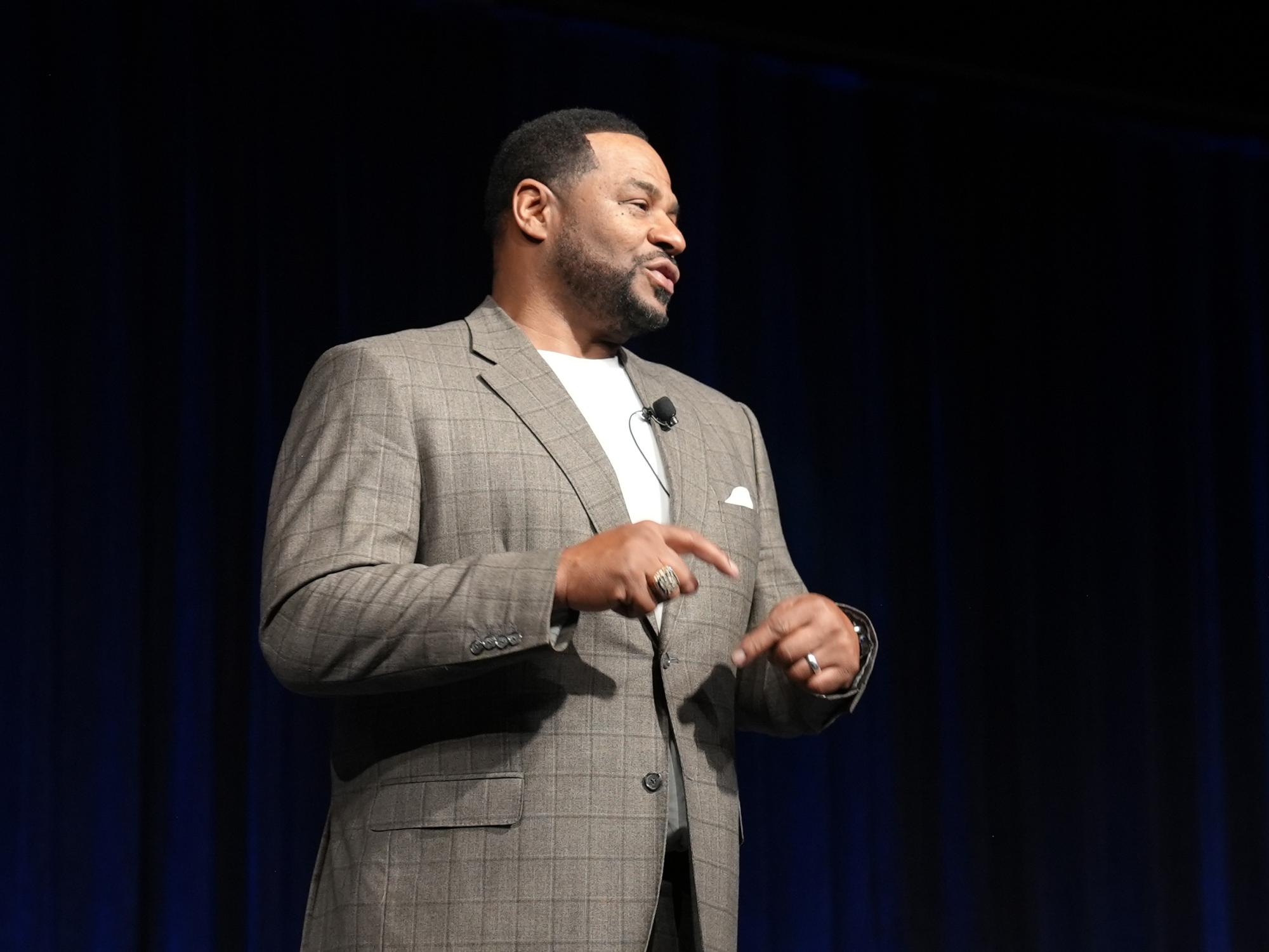 A mean speaking up on stage.