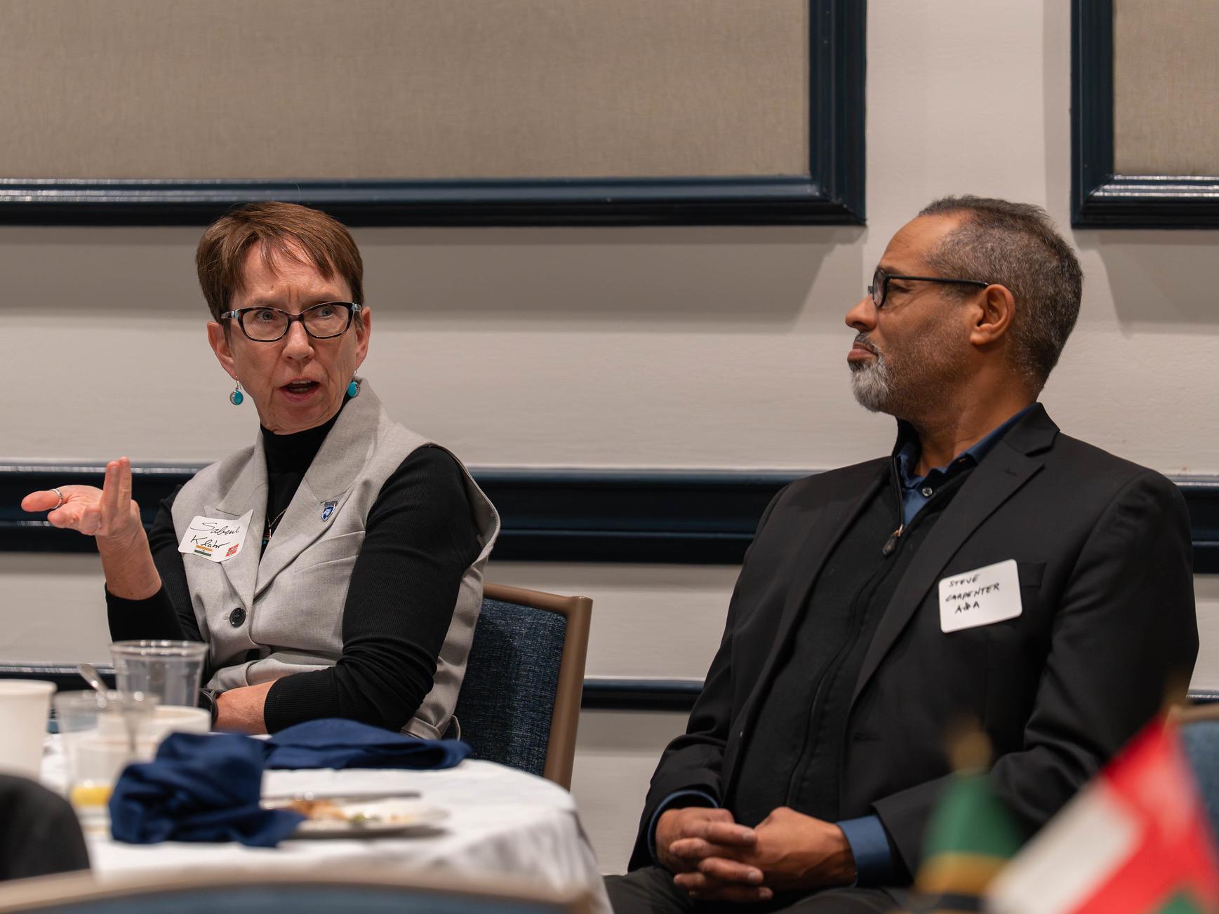 Sabine Klahr and B. Stephen Carpenter II chat at a table