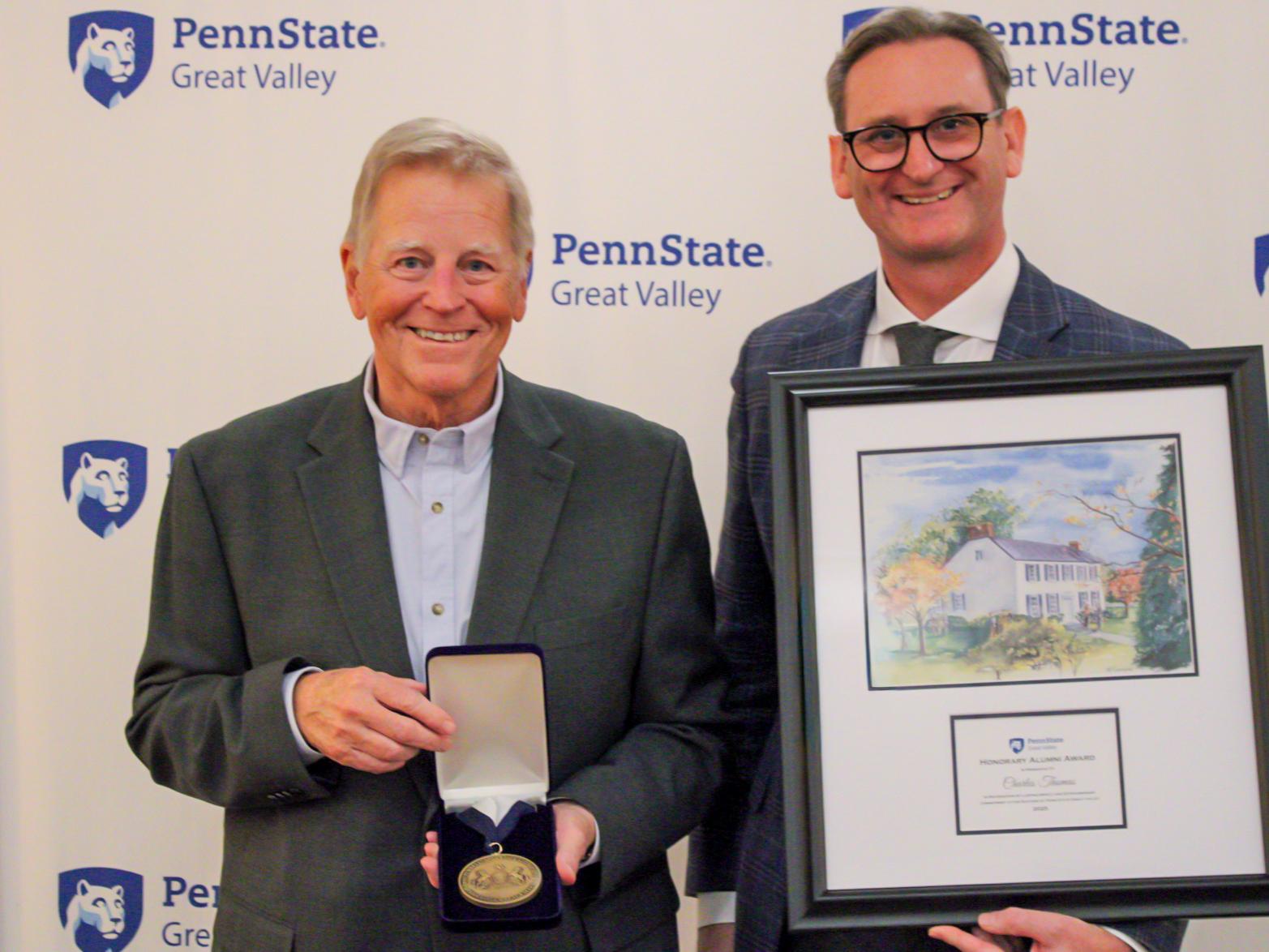 The chancellor presents a plaque and medal to an award winner.