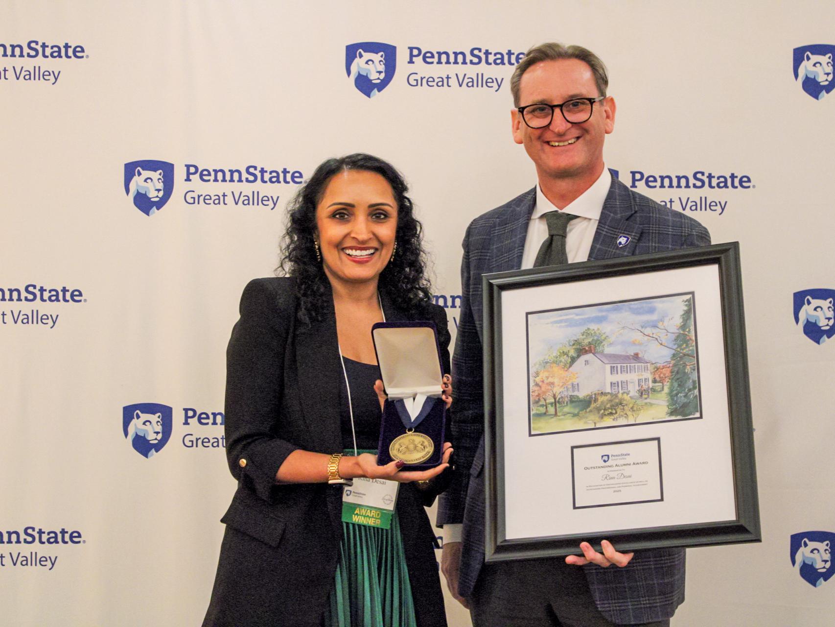 An alumna receives a plaque and medal from the chancellor. 