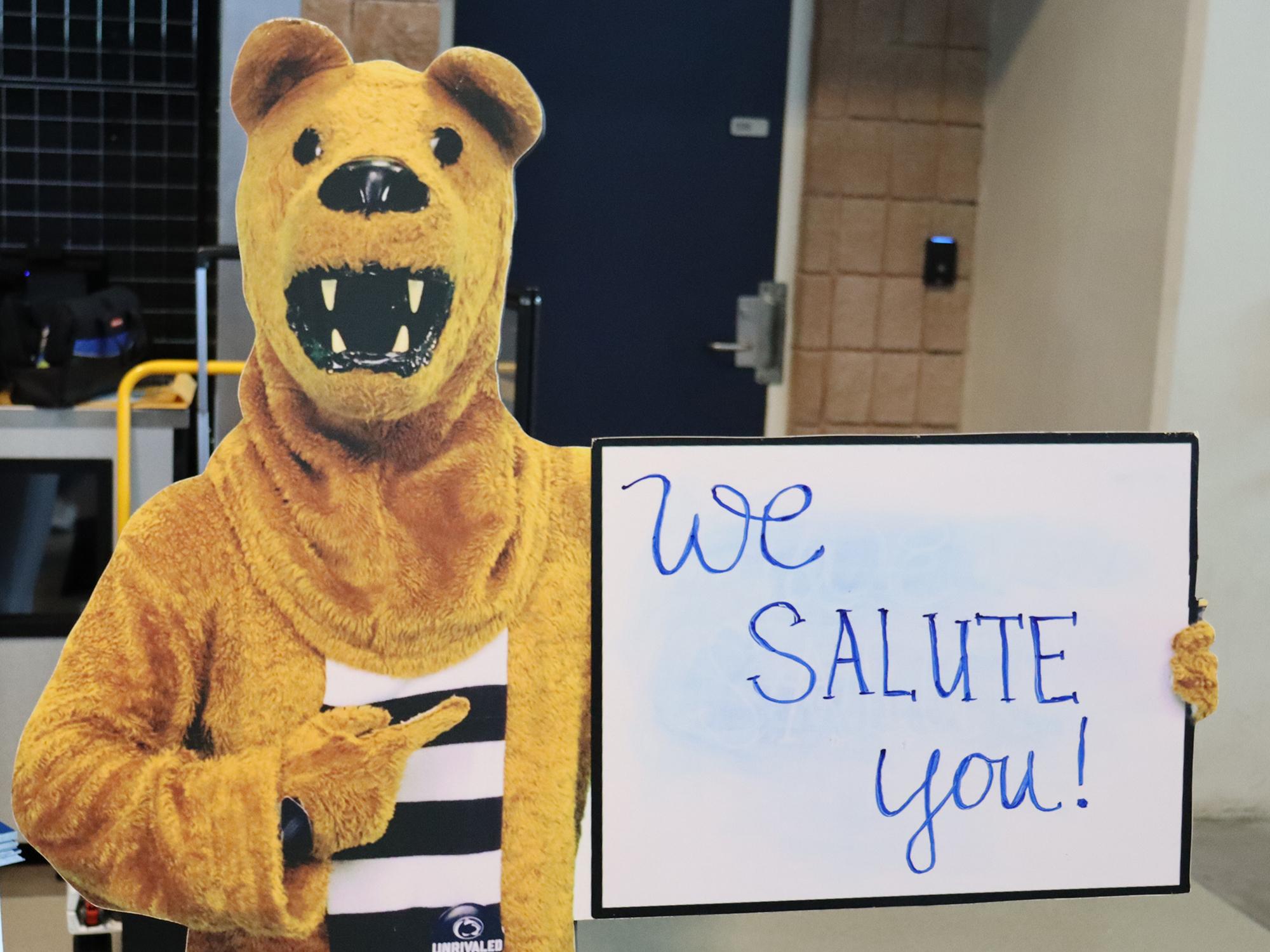 A cutout of the Nittany Lion with a sign that reads "We salute you!"
