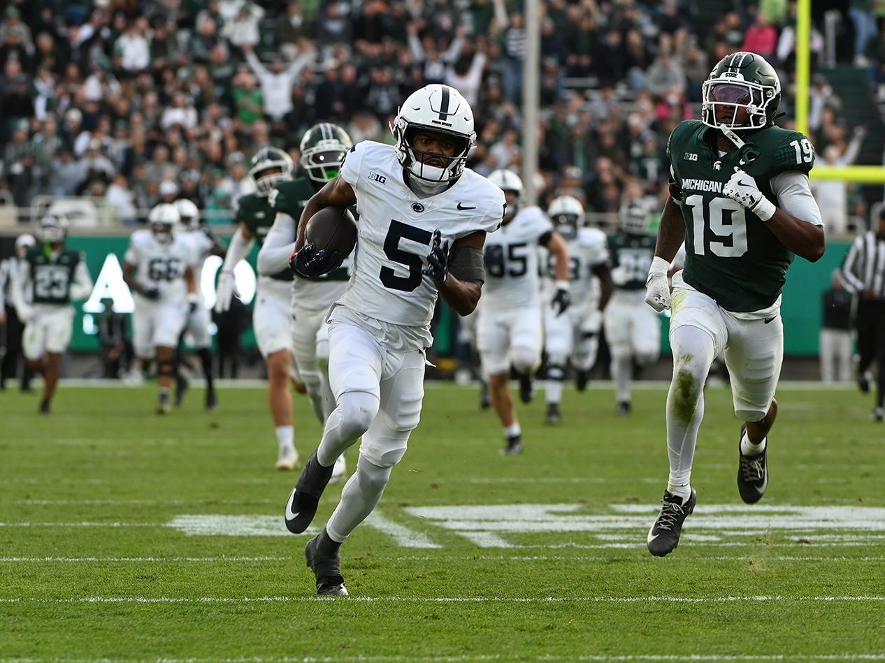 Penn State player running away from opposing players 