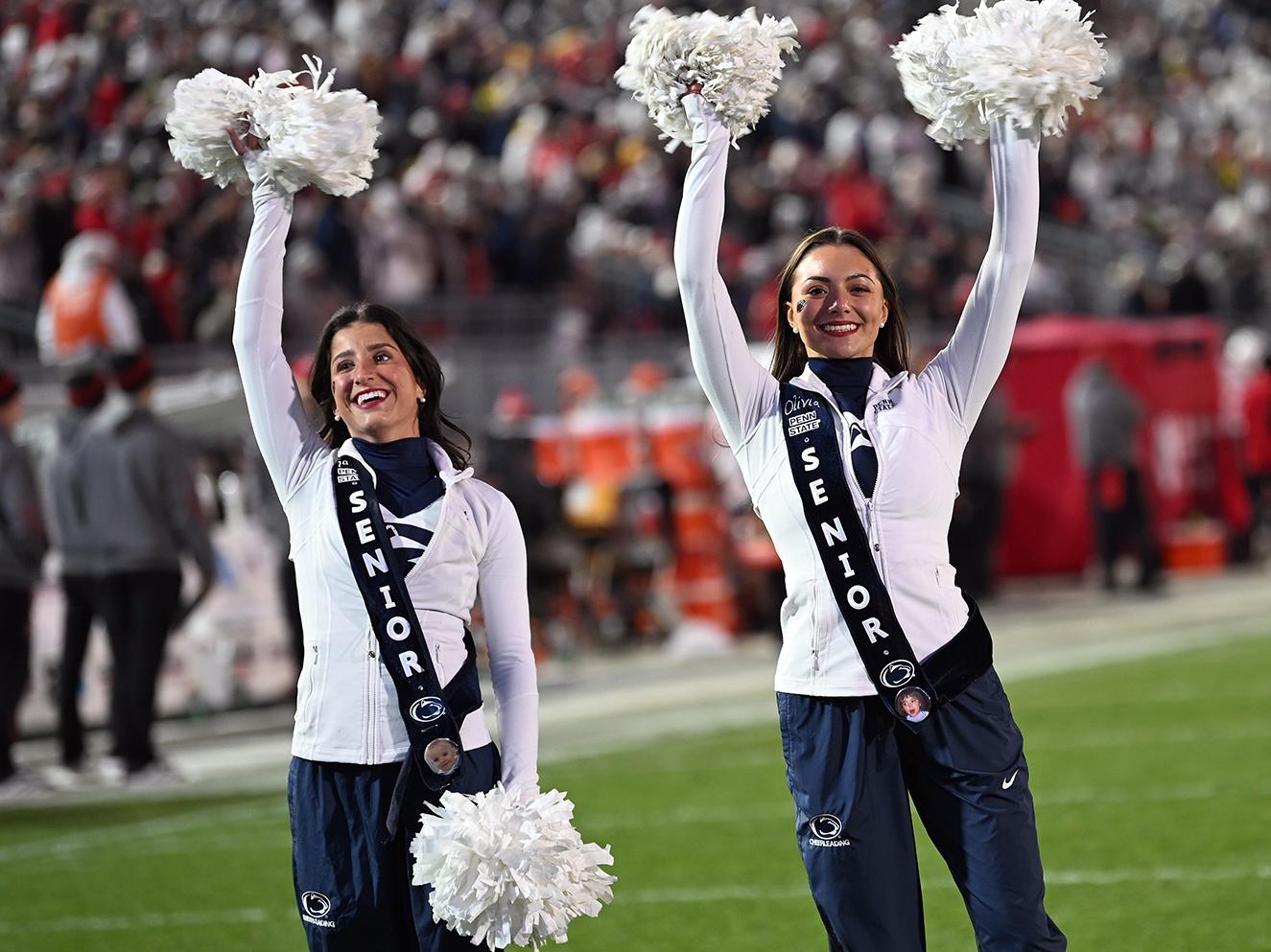 Two cheerleaders waving