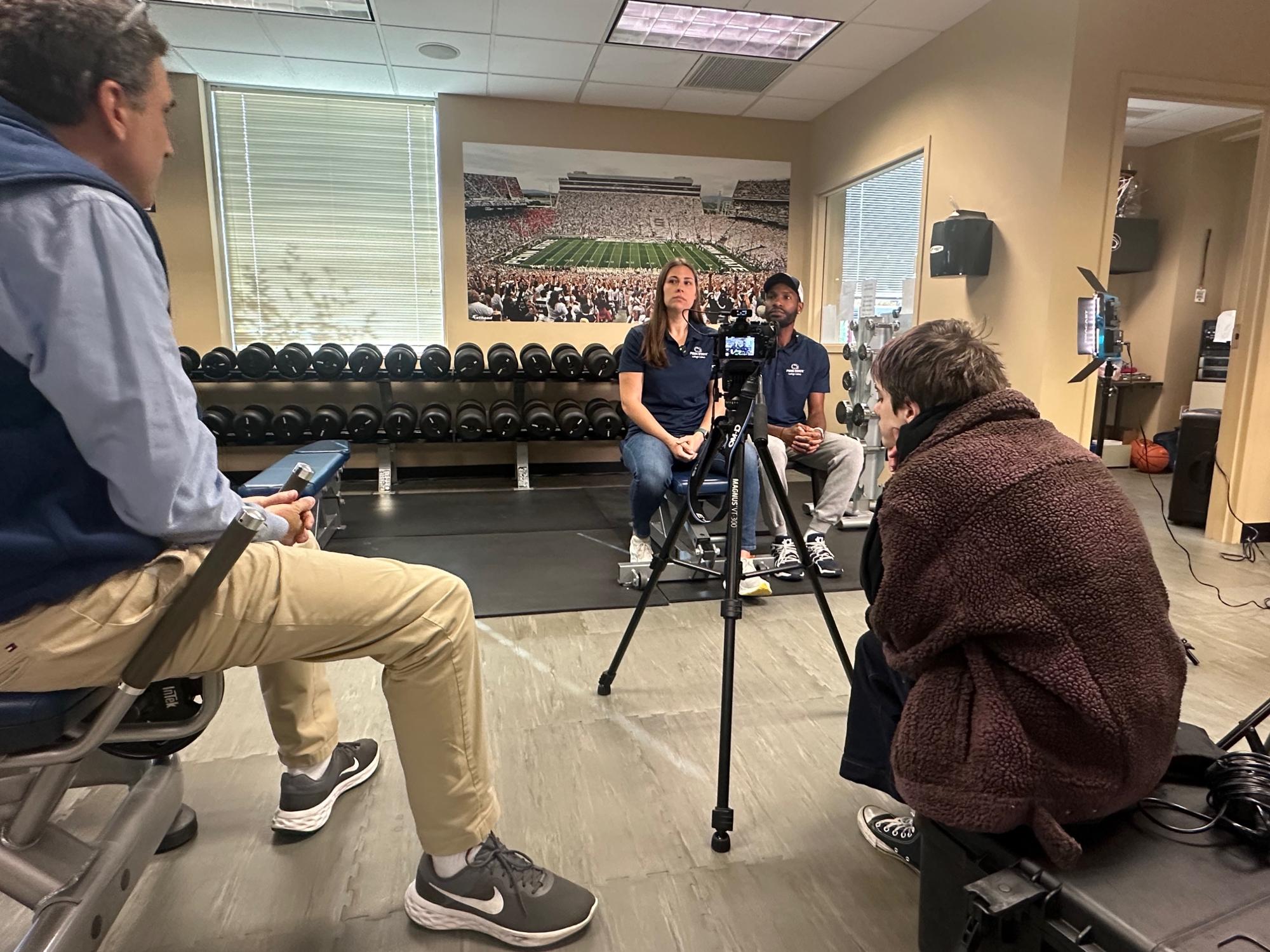 Ryan Abramson Director of Strategic Communications interviewing two people in front of a camera.