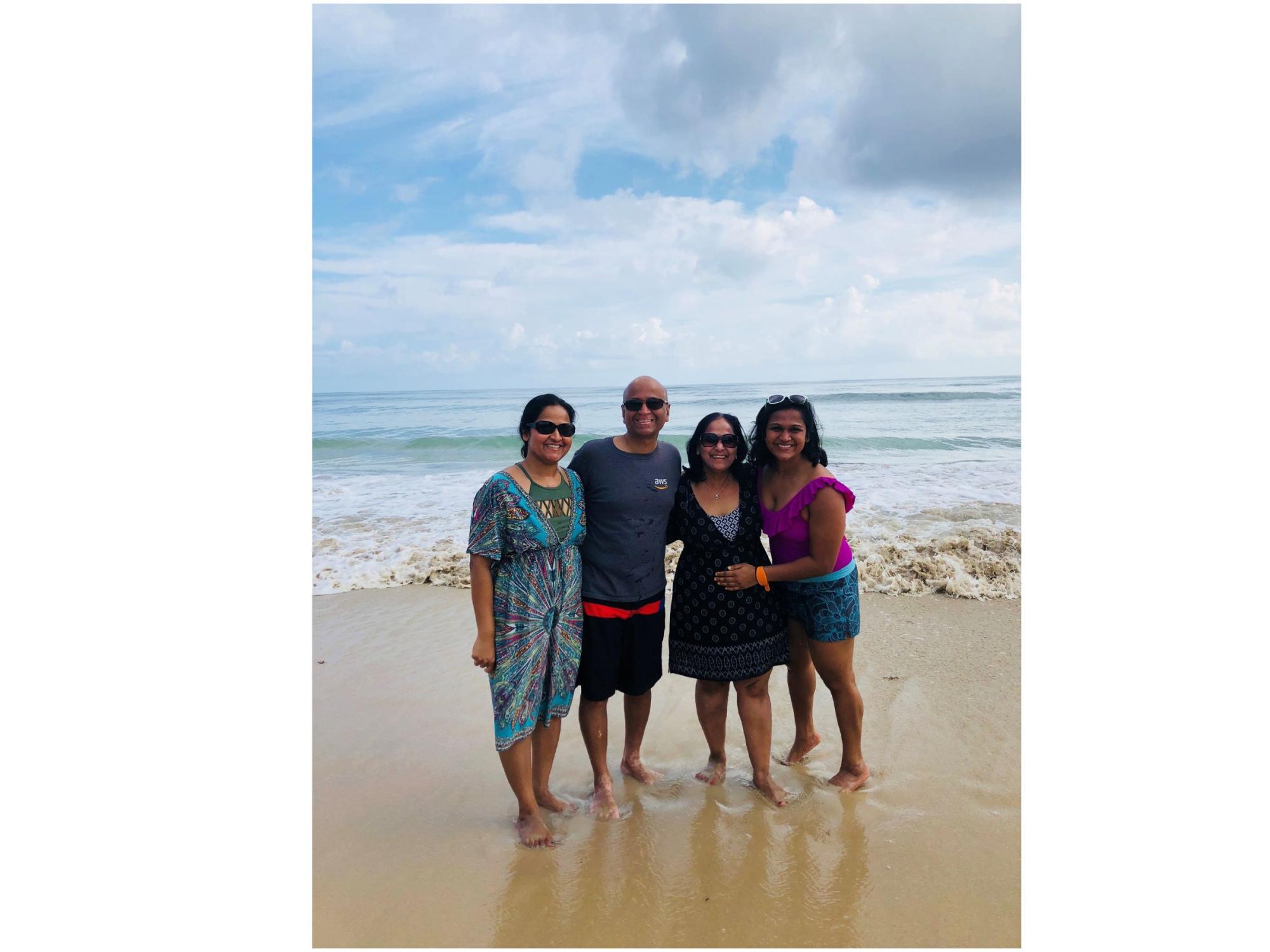 family of four on the beach with ocean in the background