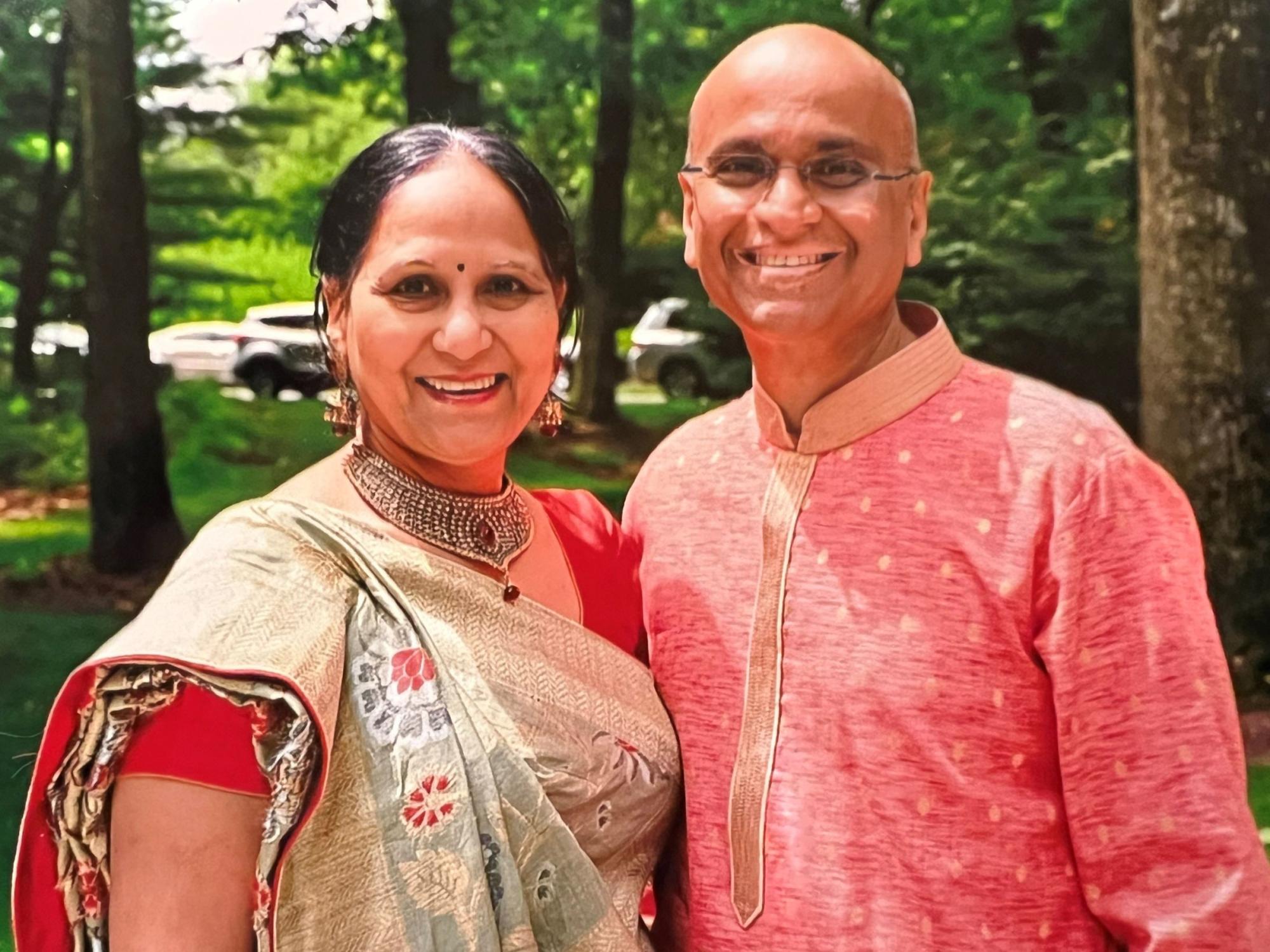 smiling dark-haired wife and bald husband in traditional garb