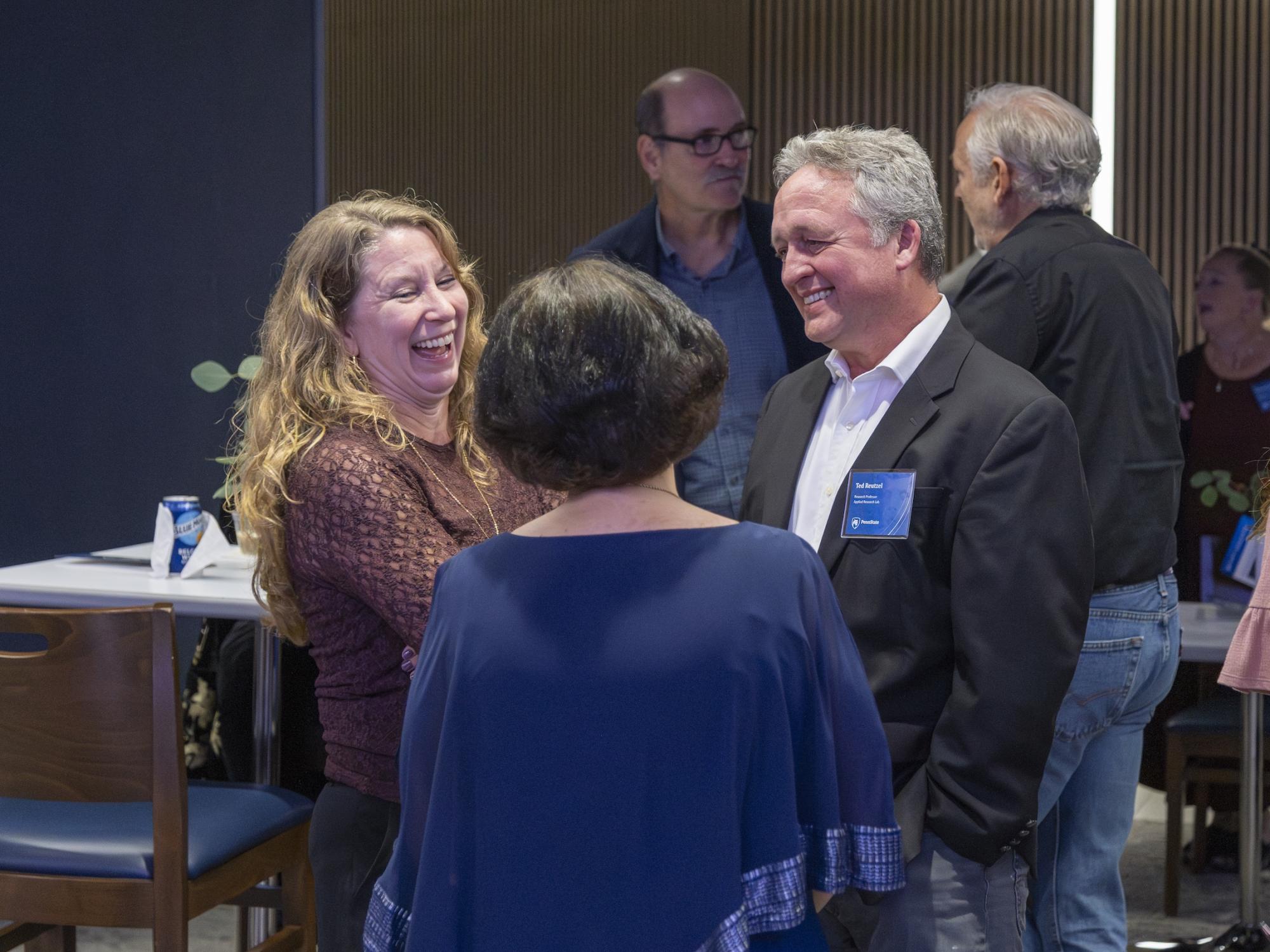Three people laughing and having conversation
