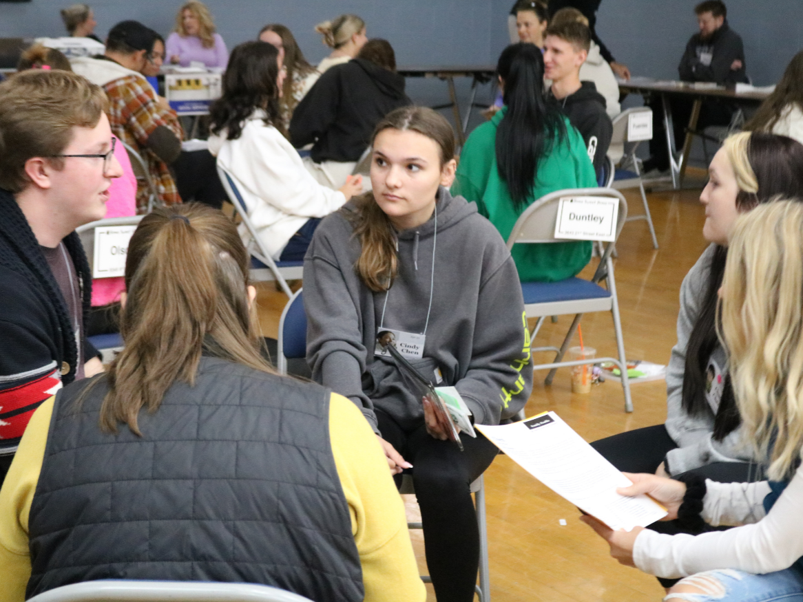 Students sit in a group and discuss