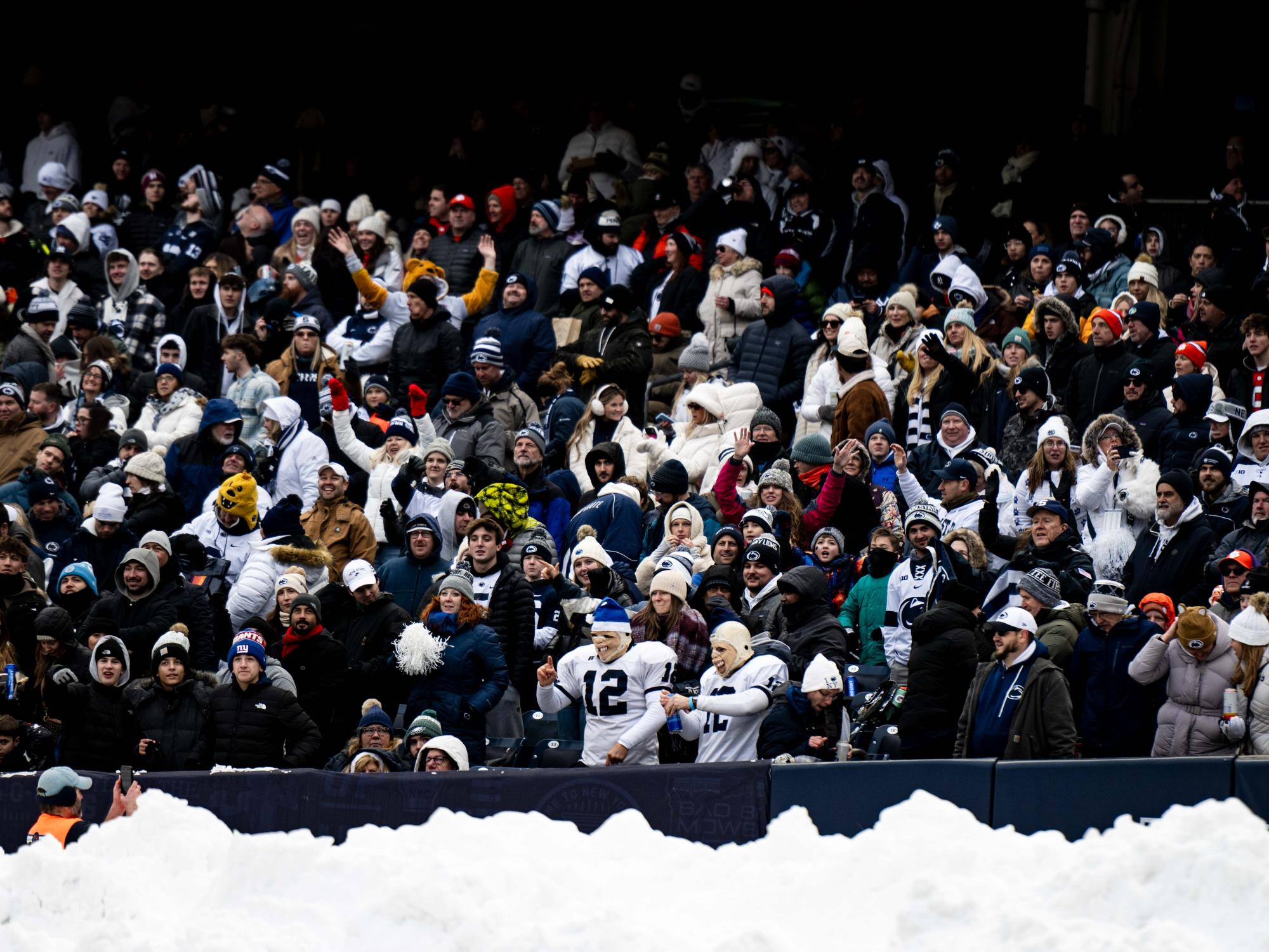 A wide photo of fans at a football game 